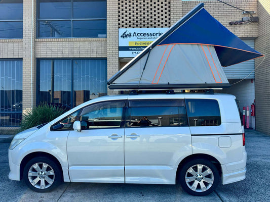 2007 Mitsubishi Delica D5 2.4L 4WD Roadest Edition with rooftop tent parked outside a shop