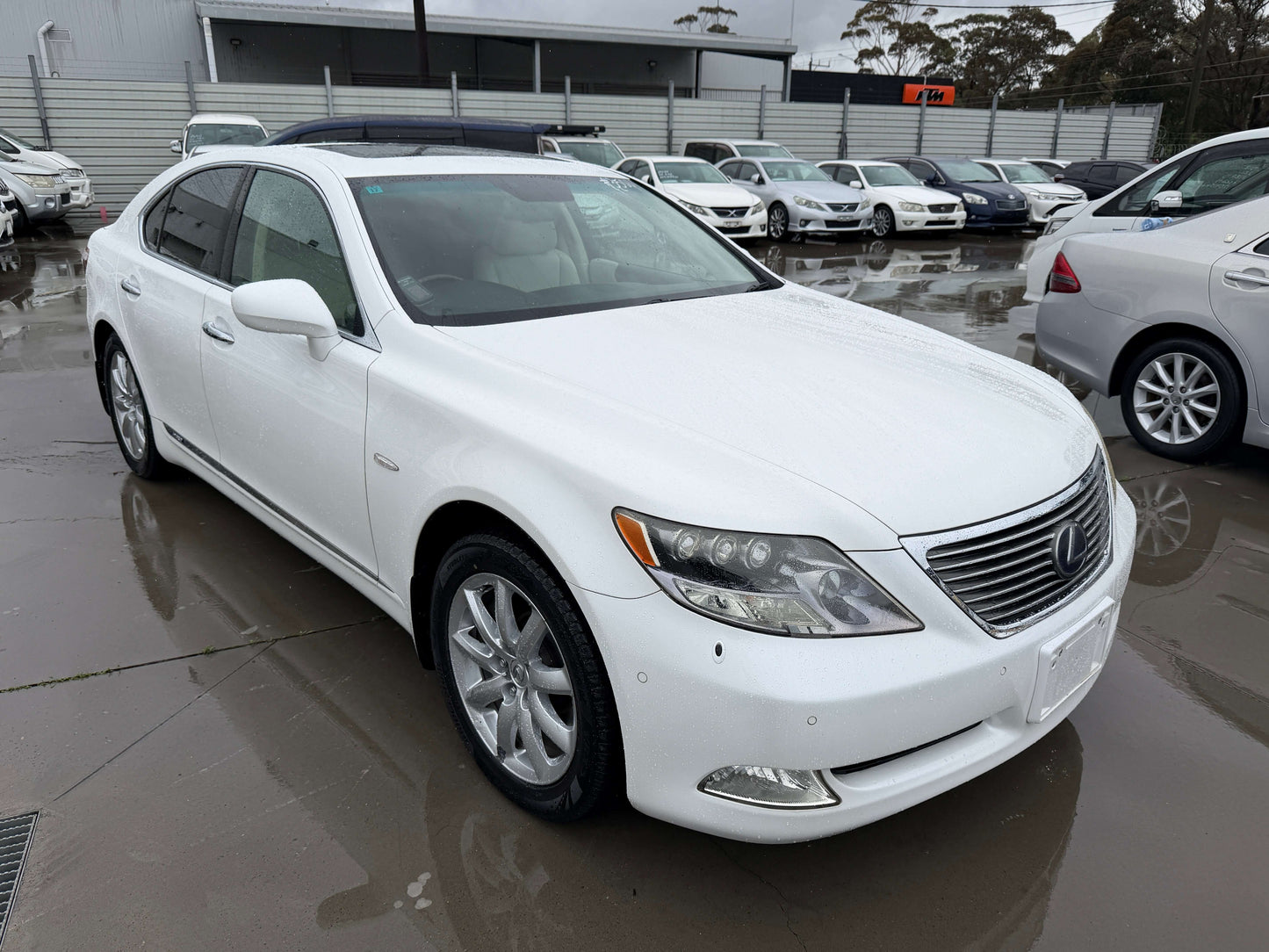 2007 Lexus LS600h AWD V8 5.0L Hybrid luxury sedan parked with other vehicles in background.