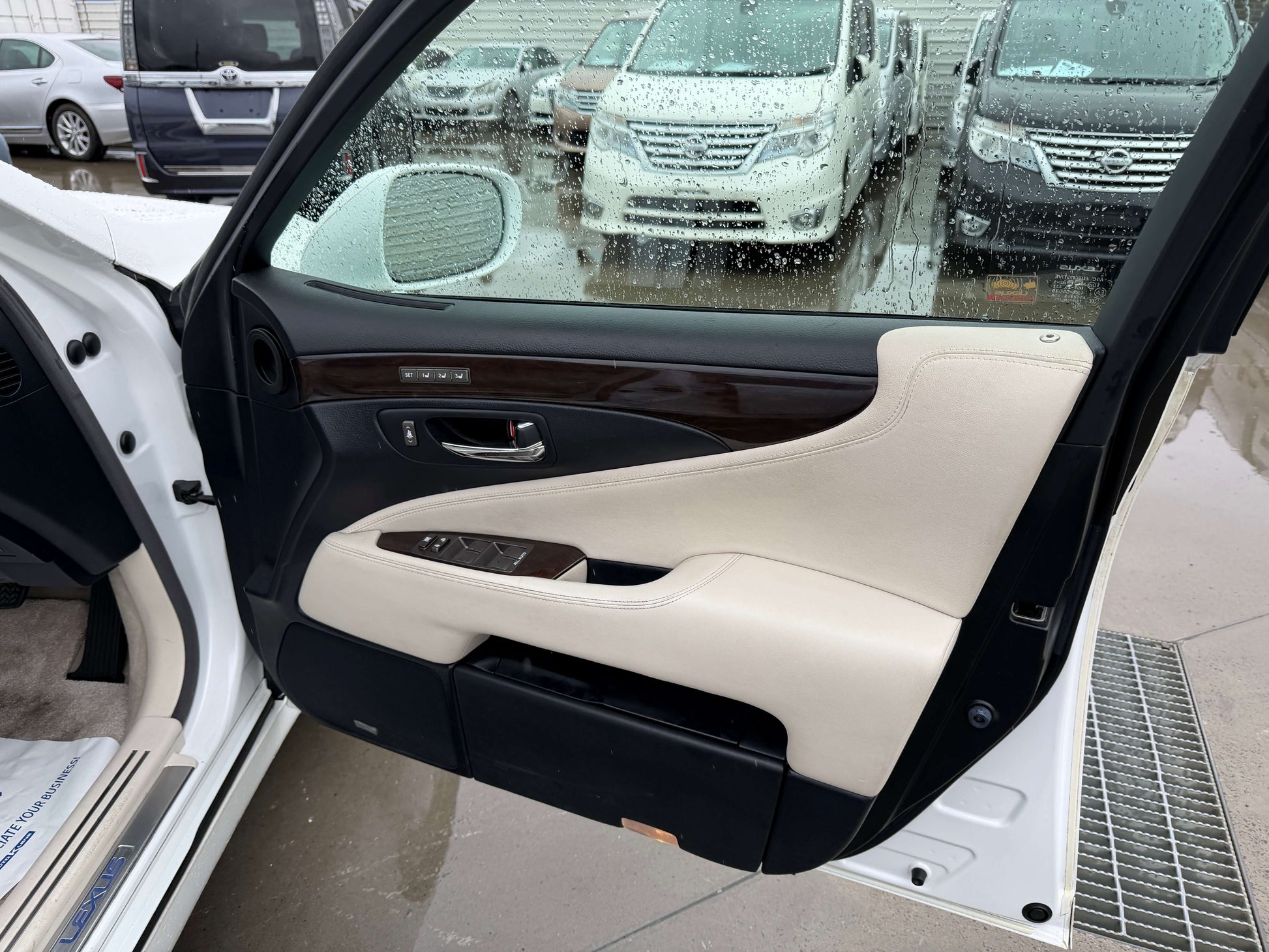 Interior door panel of a 2007 Lexus LS600h AWD V8 5.0L Hybrid Luxury sedan showcasing leather and wood accents.