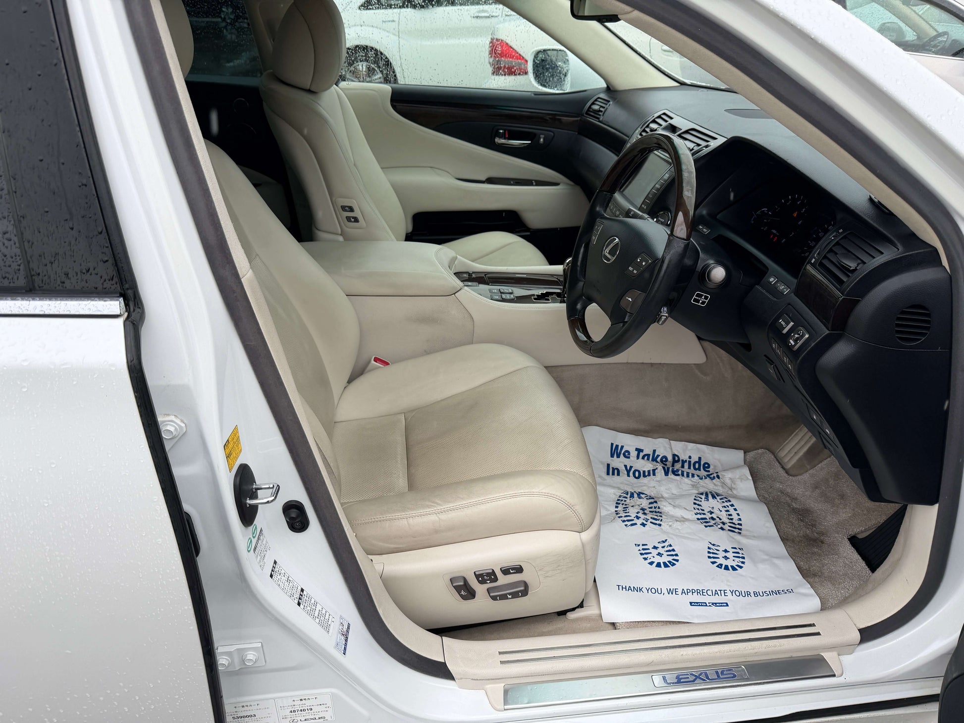 Interior view of 2007 Lexus LS600h AWD V8 5.0L Hybrid luxury sedan showing beige leather seats and dashboard.