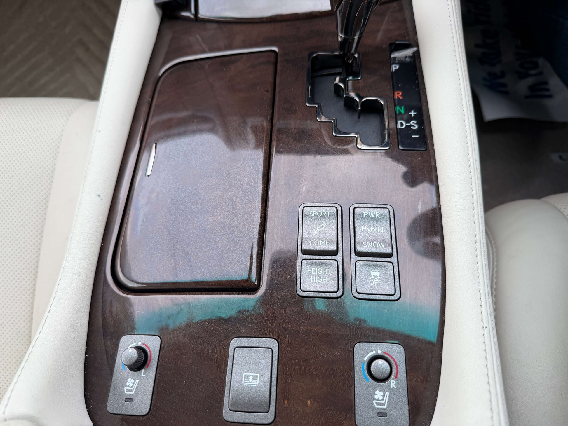 Inside view of 2007 Lexus LS600h AWD V8 5.0L Hybrid luxury sedan's center console with controls and wood trim.