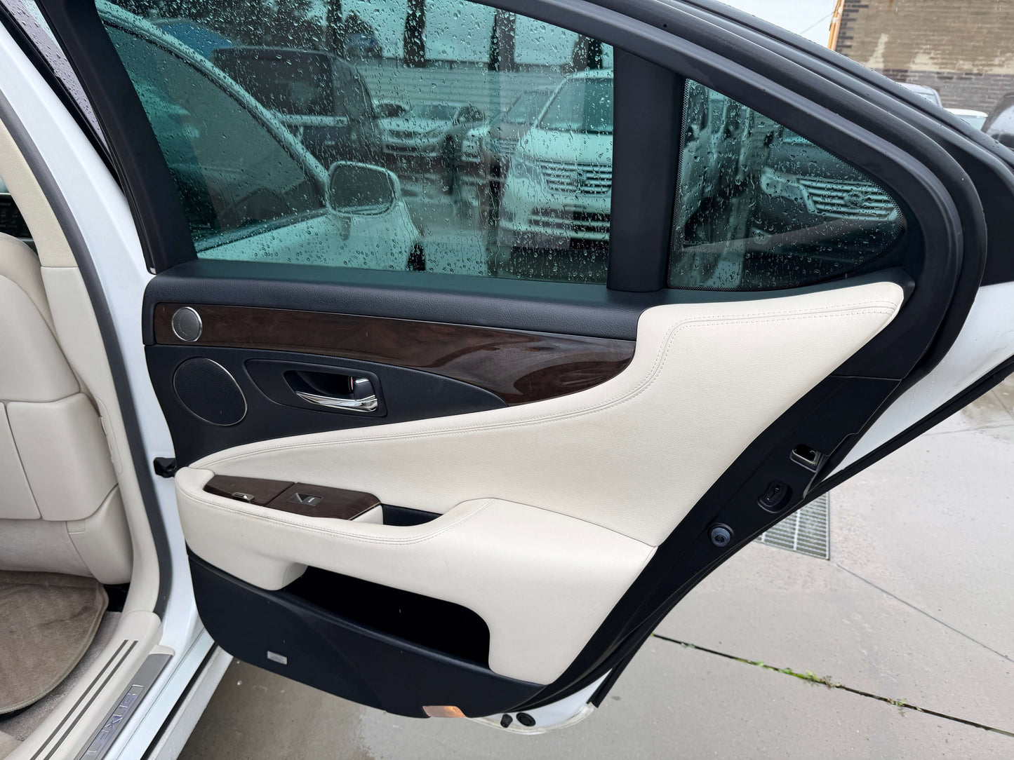 Interior view of the 2007 Lexus LS600h AWD V8 5.0L Hybrid Luxury Sedan door with beige and wood trim.