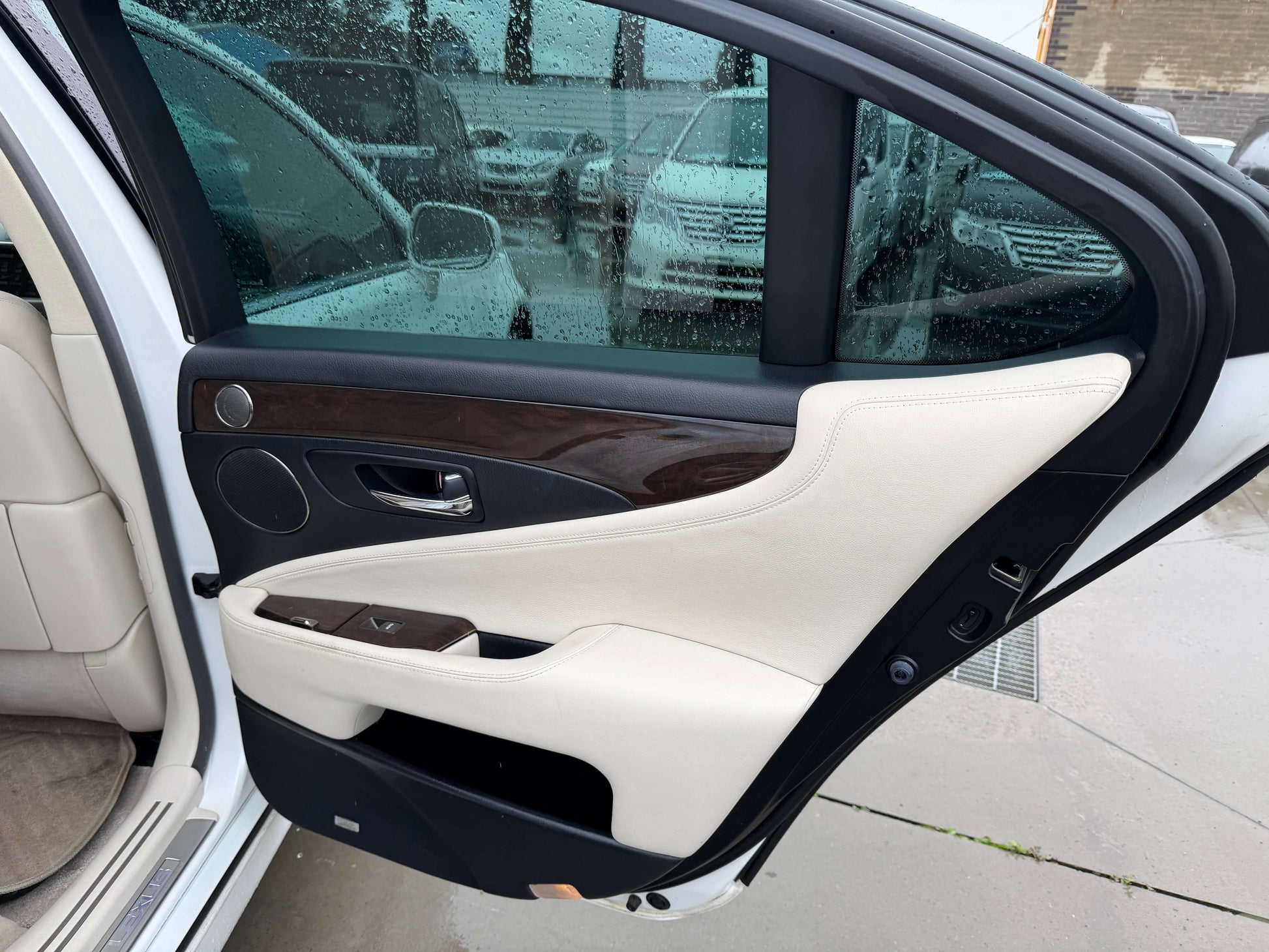Interior view of the 2007 Lexus LS600h AWD V8 5.0L Hybrid Luxury Sedan door with beige and wood trim.