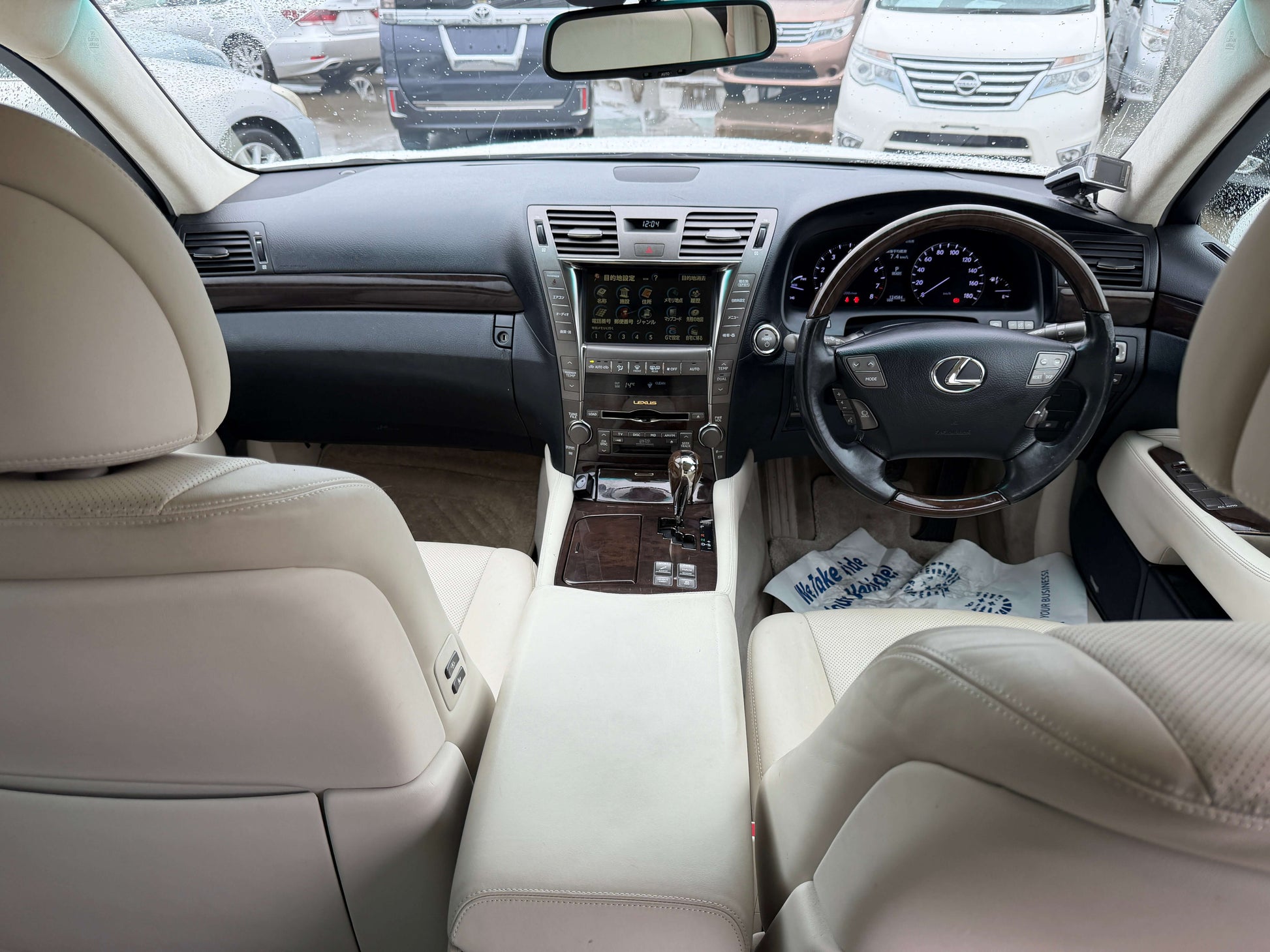 Interior view of 2007 Lexus LS600h AWD V8 5.0L Hybrid luxury sedan with beige leather seats and modern dashboard features.