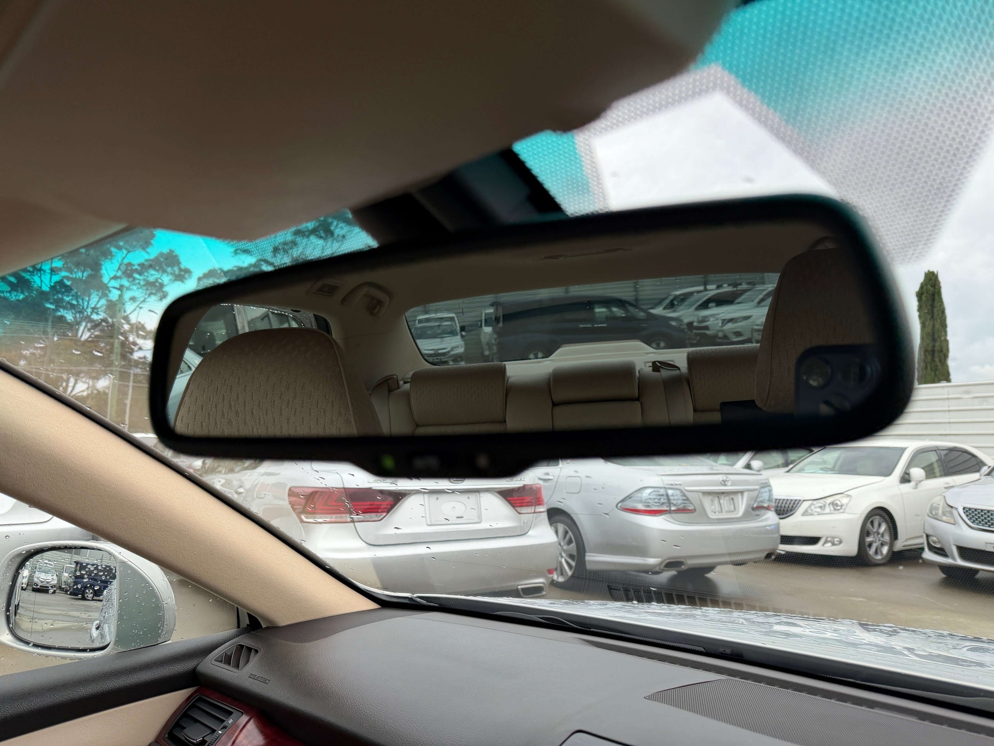 Interior view of a 2008 Toyota Crown V6 3.0L Royal Saloon Luxury Sedan's rearview mirror reflecting the back seat.