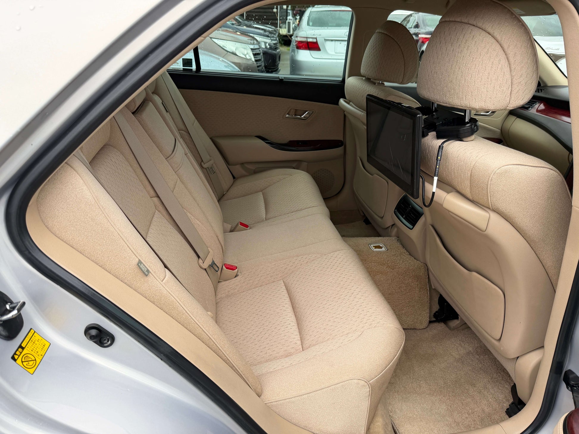 2008 Toyota Crown V6 3.0L Royal Saloon luxury sedan rear interior seating with beige upholstery and entertainment screen.