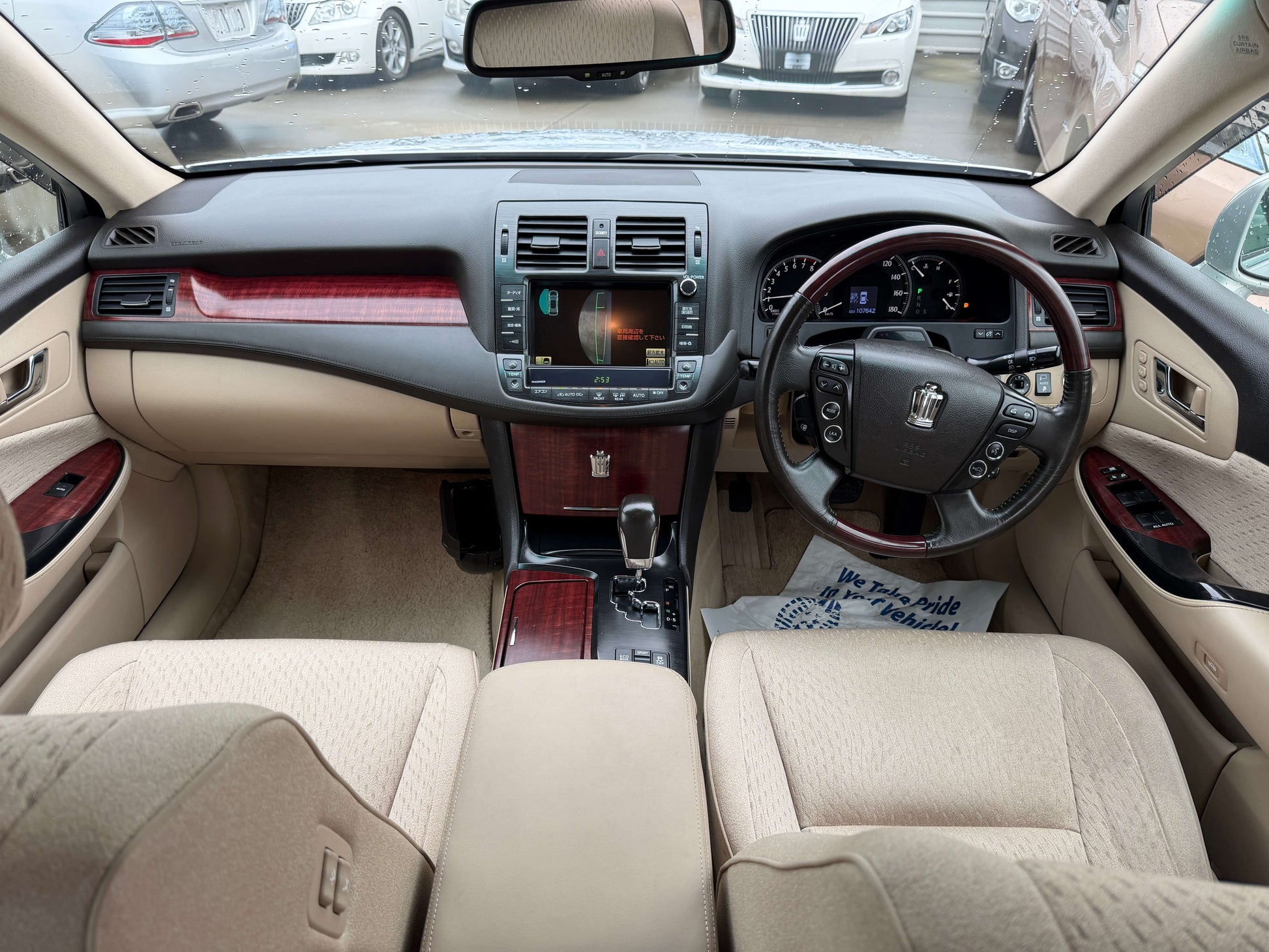 Interior view of a 2008 Toyota Crown V6 3.0L Royal Saloon Luxury Sedan with beige upholstery and wood accents.