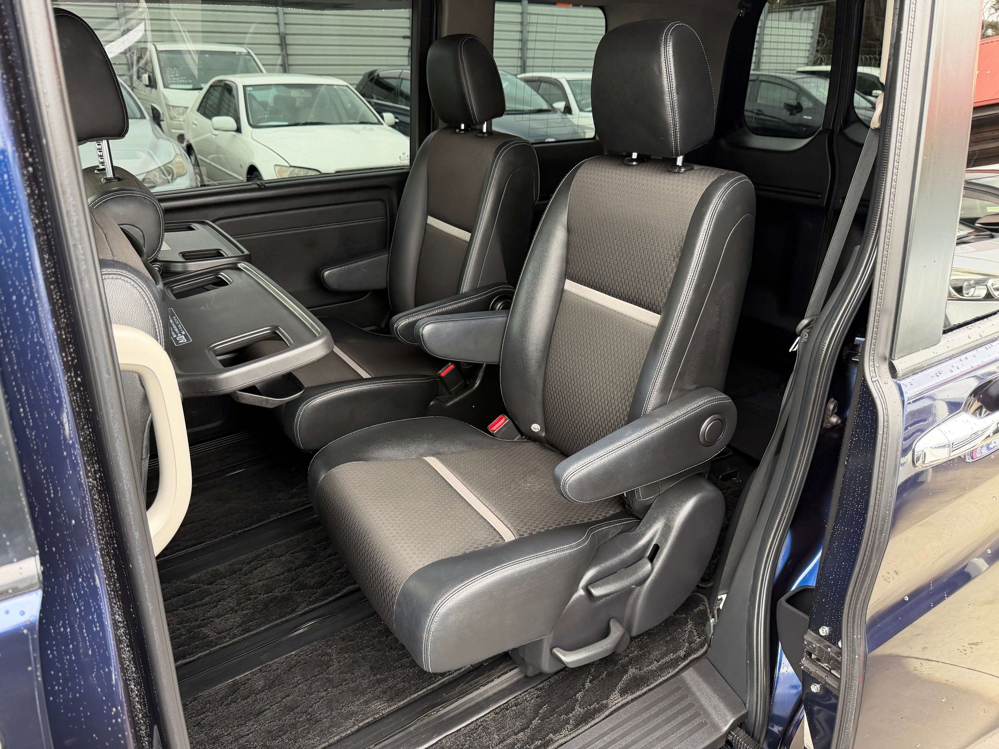 Interior seating of 2018 Honda Honda Stepwgn 2.0 Spada Hybrid with black upholstery and ample legroom.
