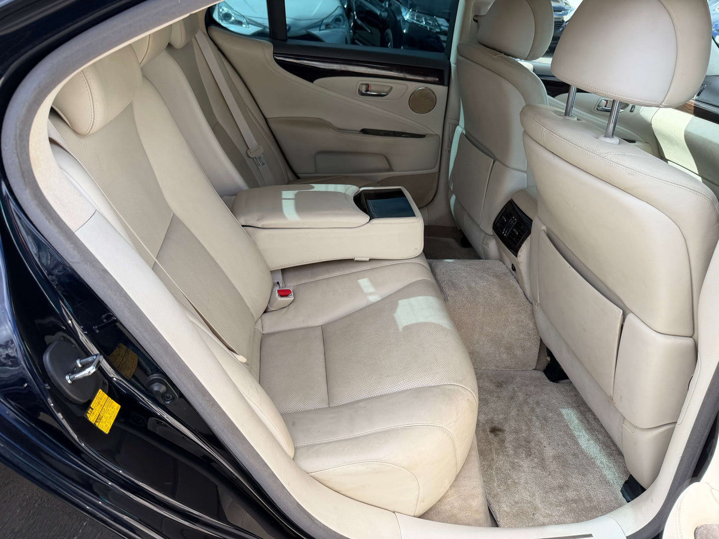 Interior view of the rear seating in a 2007 Lexus LS600h AWD V8 5.0L Hybrid luxury sedan, featuring beige leather upholstery.