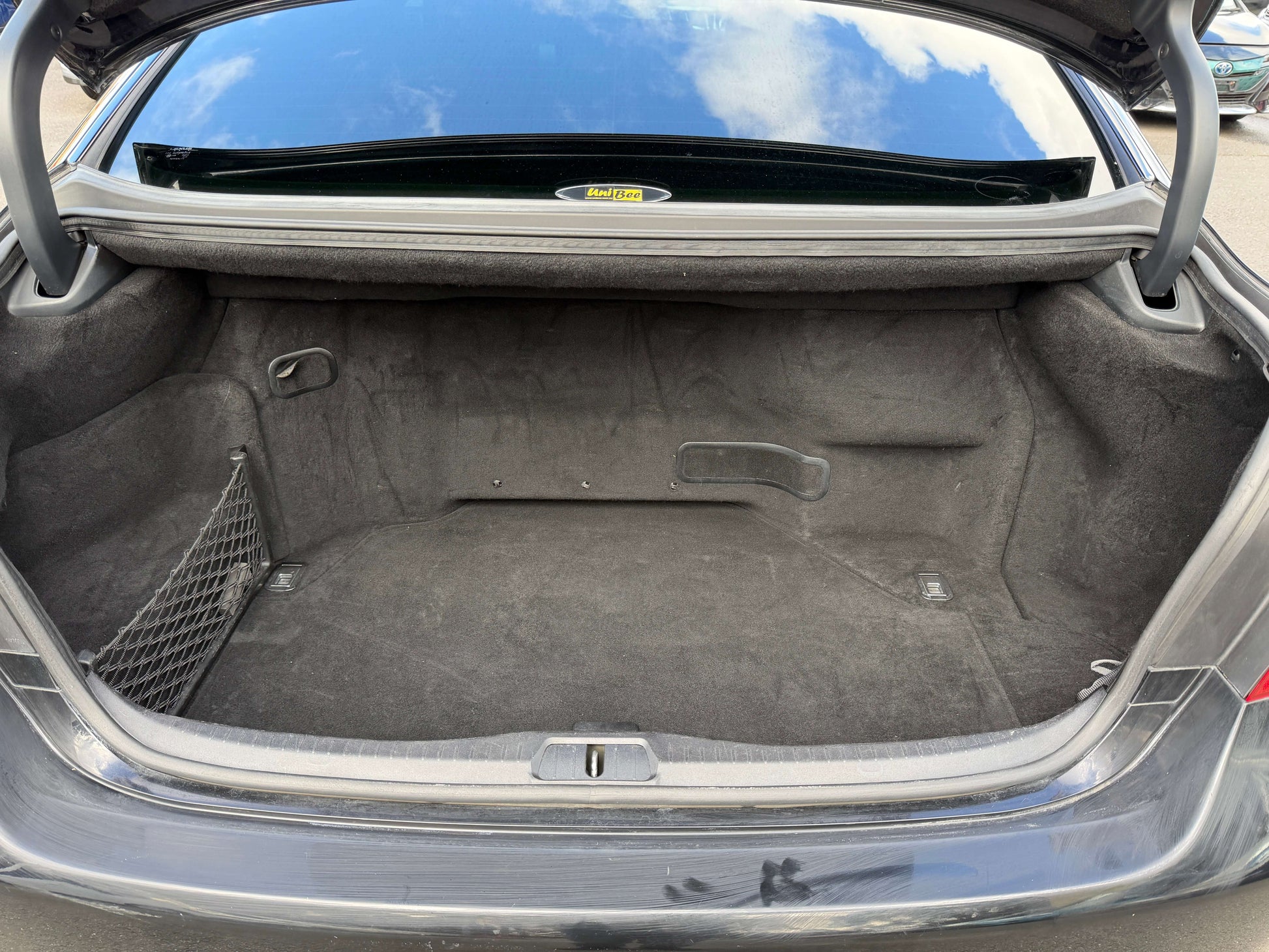 Cargo trunk space of 2007 Lexus LS600h AWD V8 5.0L Hybrid Sedan, empty with carpeted interior.