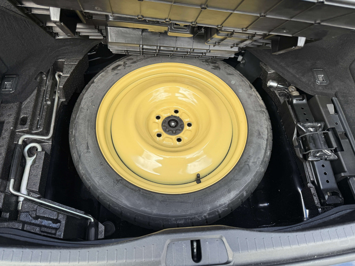 Spare tire in trunk of 2007 Lexus LS600h AWD V8 5.0L Hybrid, featuring a yellow rim.