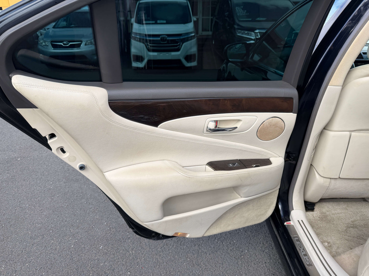 Interior door panel of a 2007 Lexus LS600h AWD V8 5.0L Hybrid Luxury Sedan with wood accents and beige upholstery.