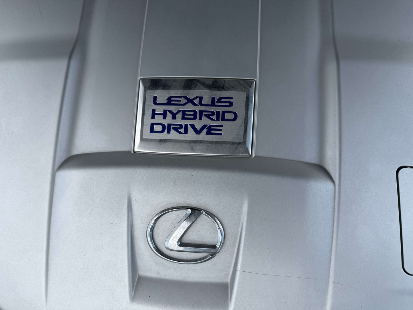 Lexus Hybrid Drive emblem on the engine cover of a 2007 Lexus LS600h AWD V8 5.0L Hybrid luxury sedan.