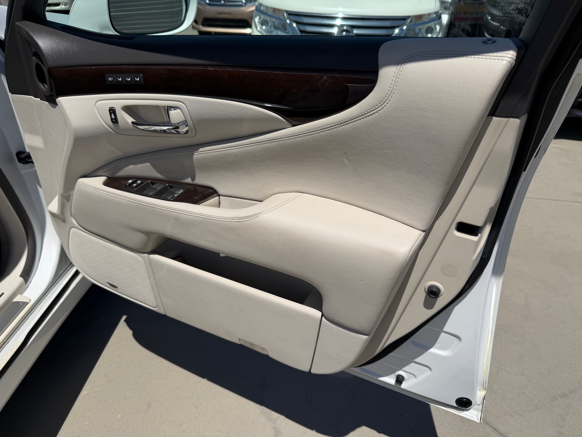 Interior view of 2007 Lexus LS600hL AWD V8 5.0L Hybrid Luxury Sedan door panel, showcasing luxury finishes and features.