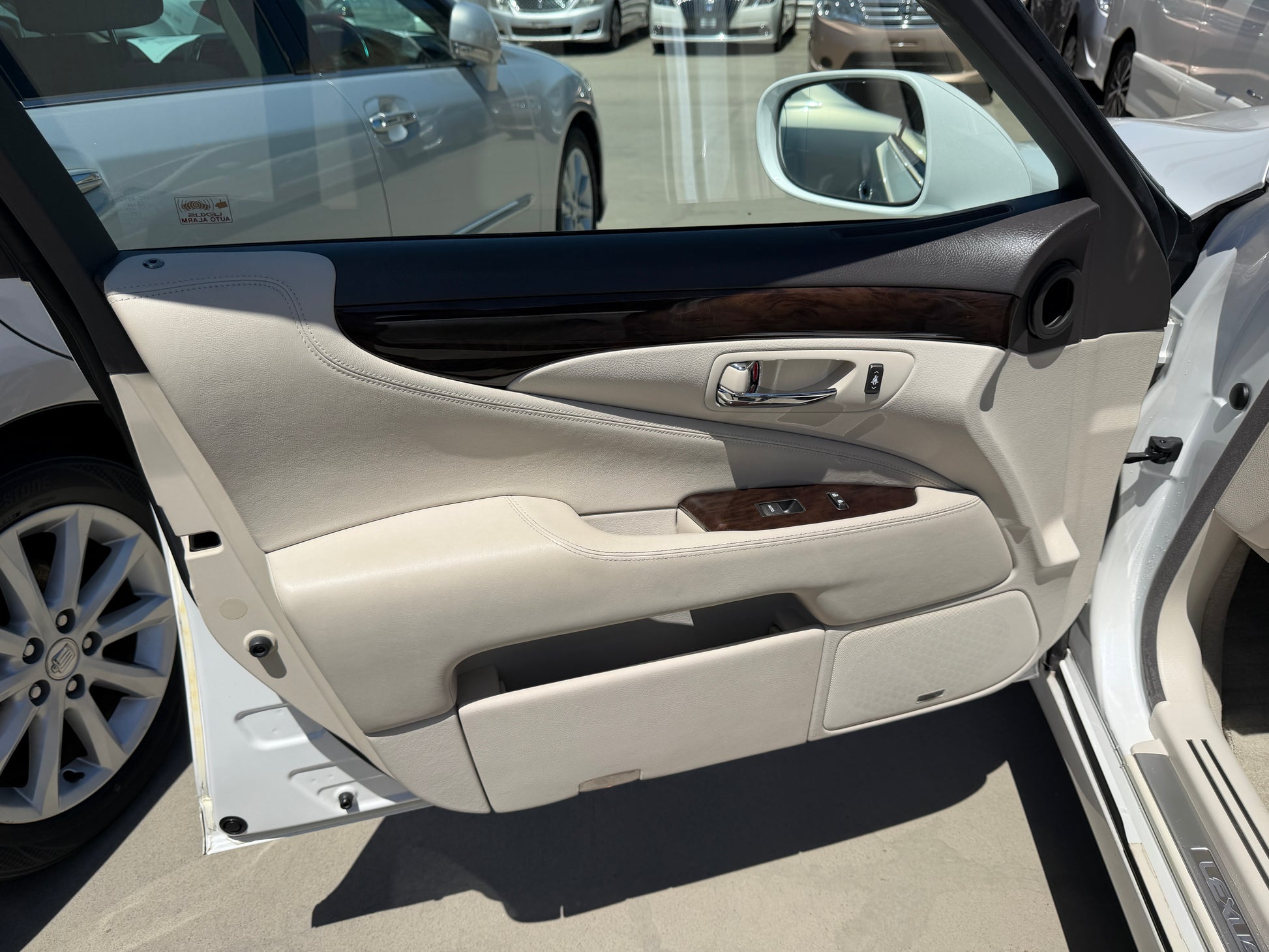 Interior view of the 2007 Lexus LS600hL AWD V8 5.0L Hybrid luxury sedan's door with cream leather and wood trim.
