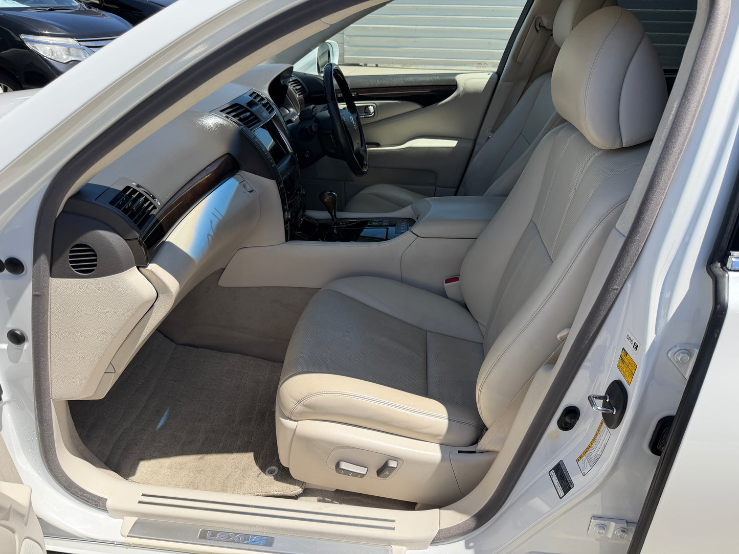 Interior view of 2007 Lexus LS600hL AWD V8 5.0L Hybrid Luxury Sedan showcasing its plush beige leather seating.