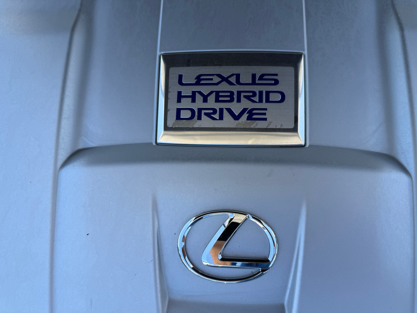2007 Lexus LS600hL AWD V8 5.0L Hybrid Lexus Hybrid Drive badge on a vehicle engine cover, showcasing hybrid technology and luxury design.