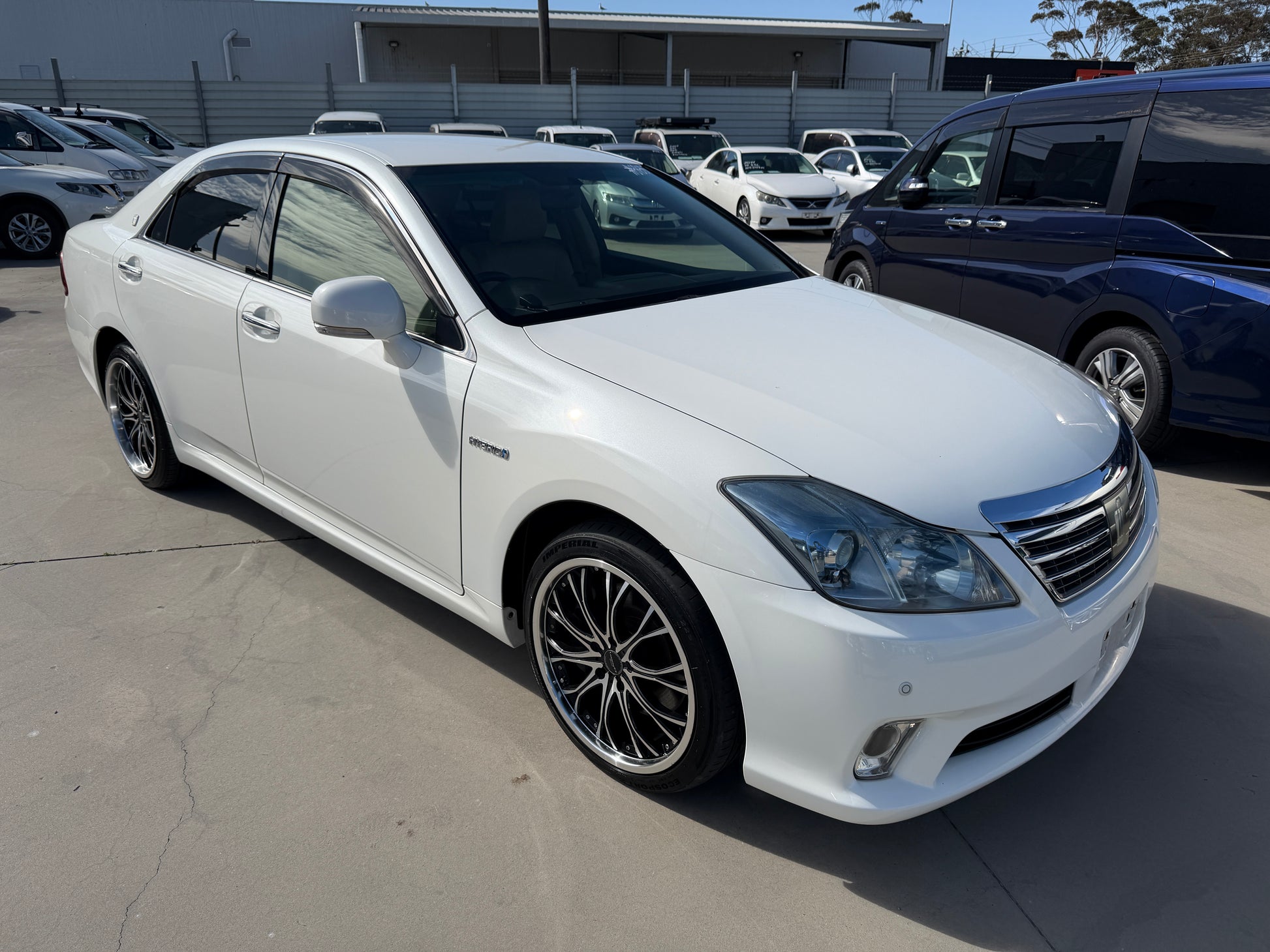 2012 Toyota Crown V6 3.5L Hybrid Luxury Sedan in white with sleek design and sporty wheels.