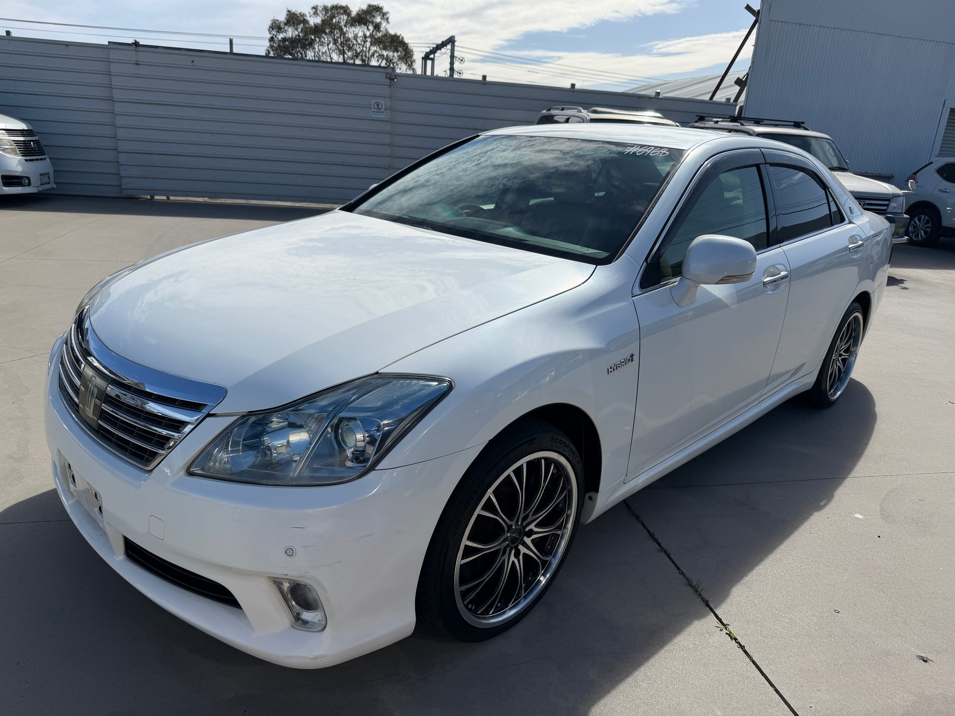 2012 Toyota Crown V6 3.5L Hybrid Luxury Sedan in white color with stylish wheels, showcasing elegant design and performance.