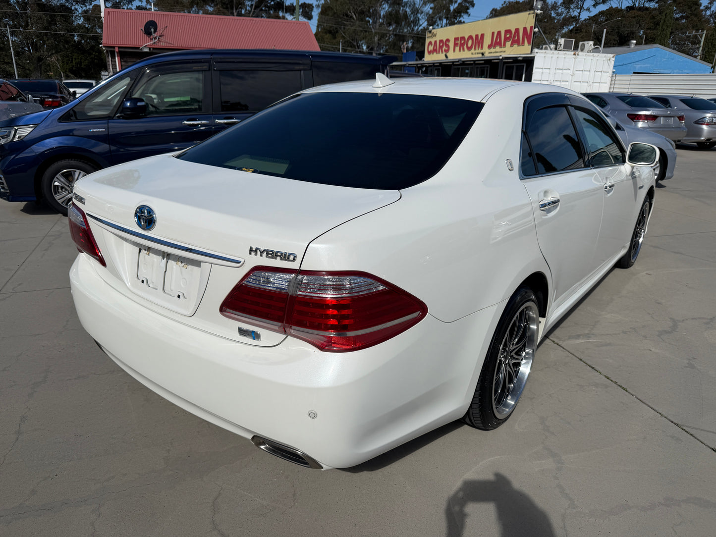 2012 Toyota Crown V6 3.5L Hybrid Luxury Sedan shown from the rear, highlighting its elegant design and hybrid badge.