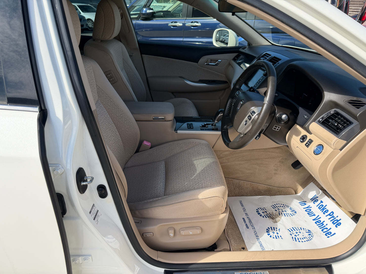 Interior view of the 2012 Toyota Crown V6 3.5L Hybrid Luxury Sedan showcasing the driver's seat and dashboard.