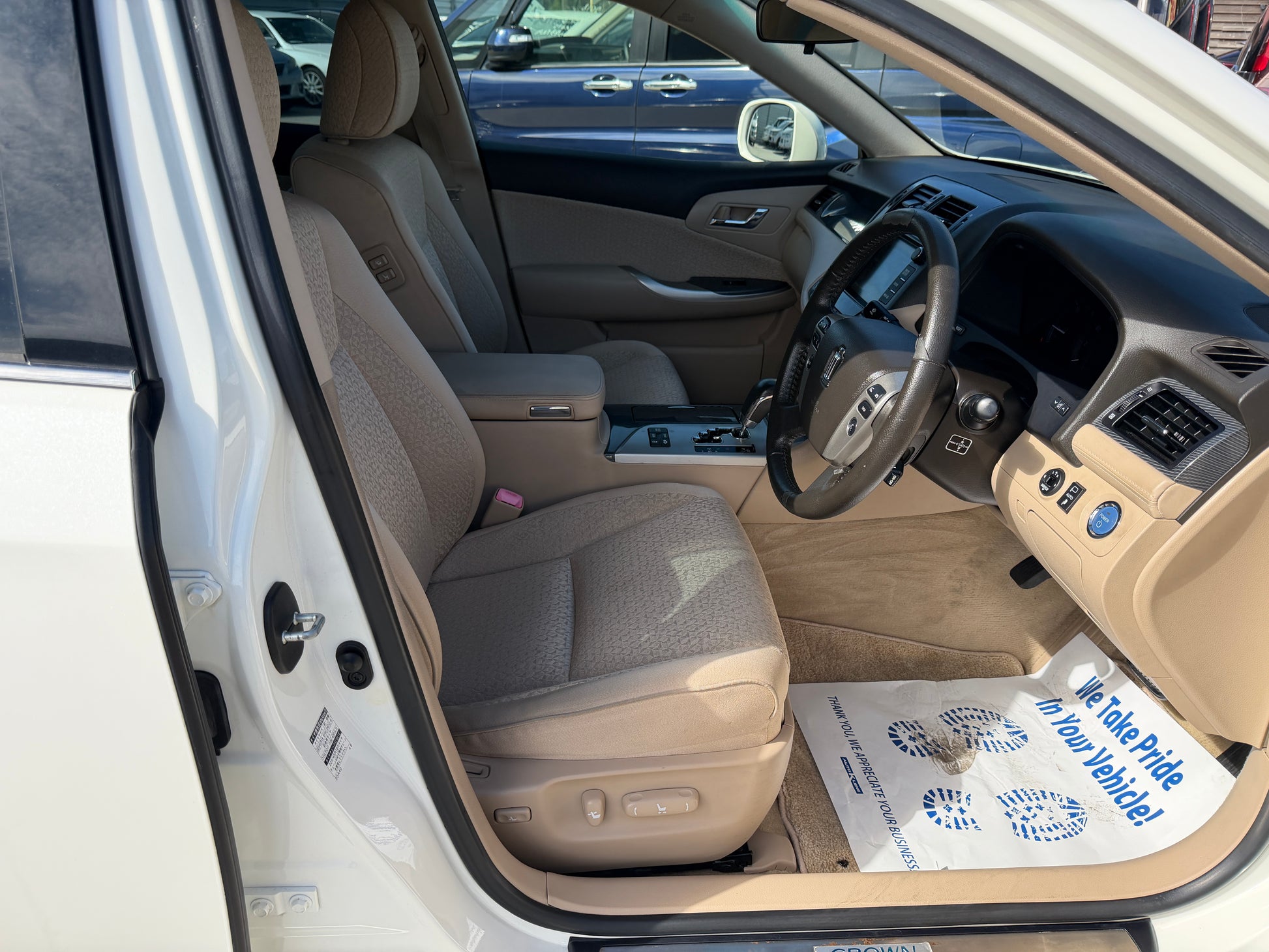 Interior view of the 2012 Toyota Crown V6 3.5L Hybrid Luxury Sedan showcasing the driver's seat and dashboard.