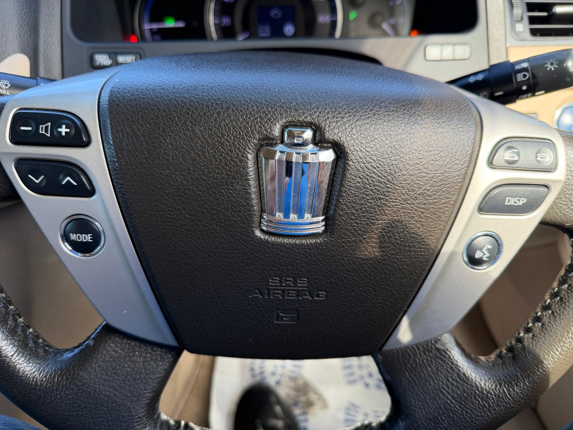 2012 Toyota Crown V6 3.5L Hybrid Luxury Sedan steering wheel with controls and logo.