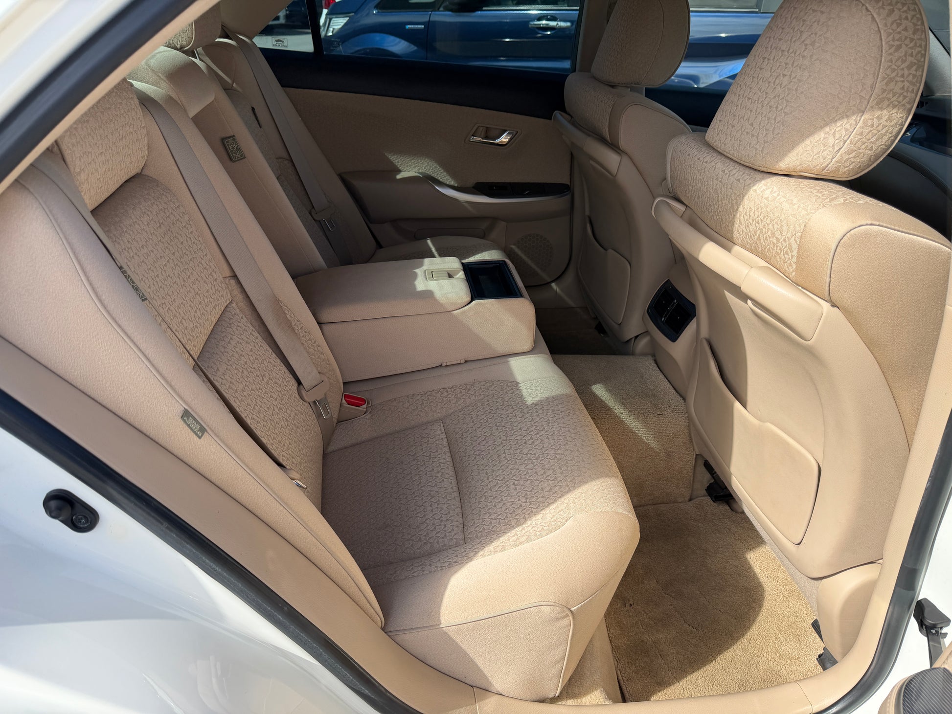 Interior view of the back seat of a 2012 Toyota Crown V6 3.5L Hybrid Luxury Sedan showing spacious and comfortable seating.