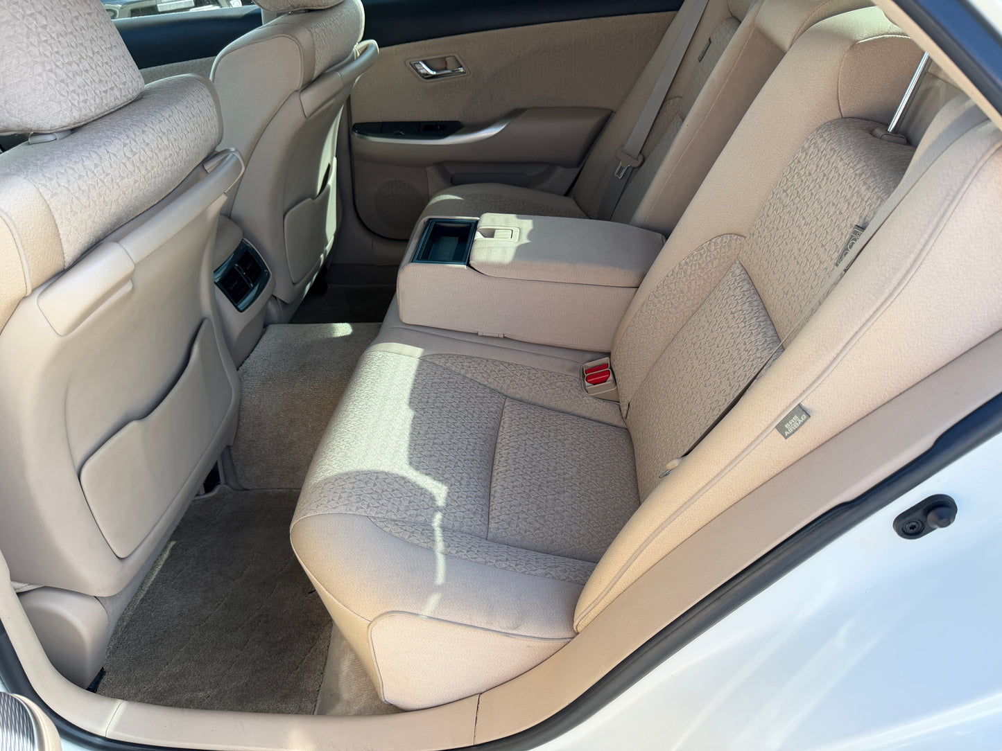 Interior view of the back seat in a 2012 Toyota Crown V6 3.5L Hybrid, showcasing luxury seating and space.