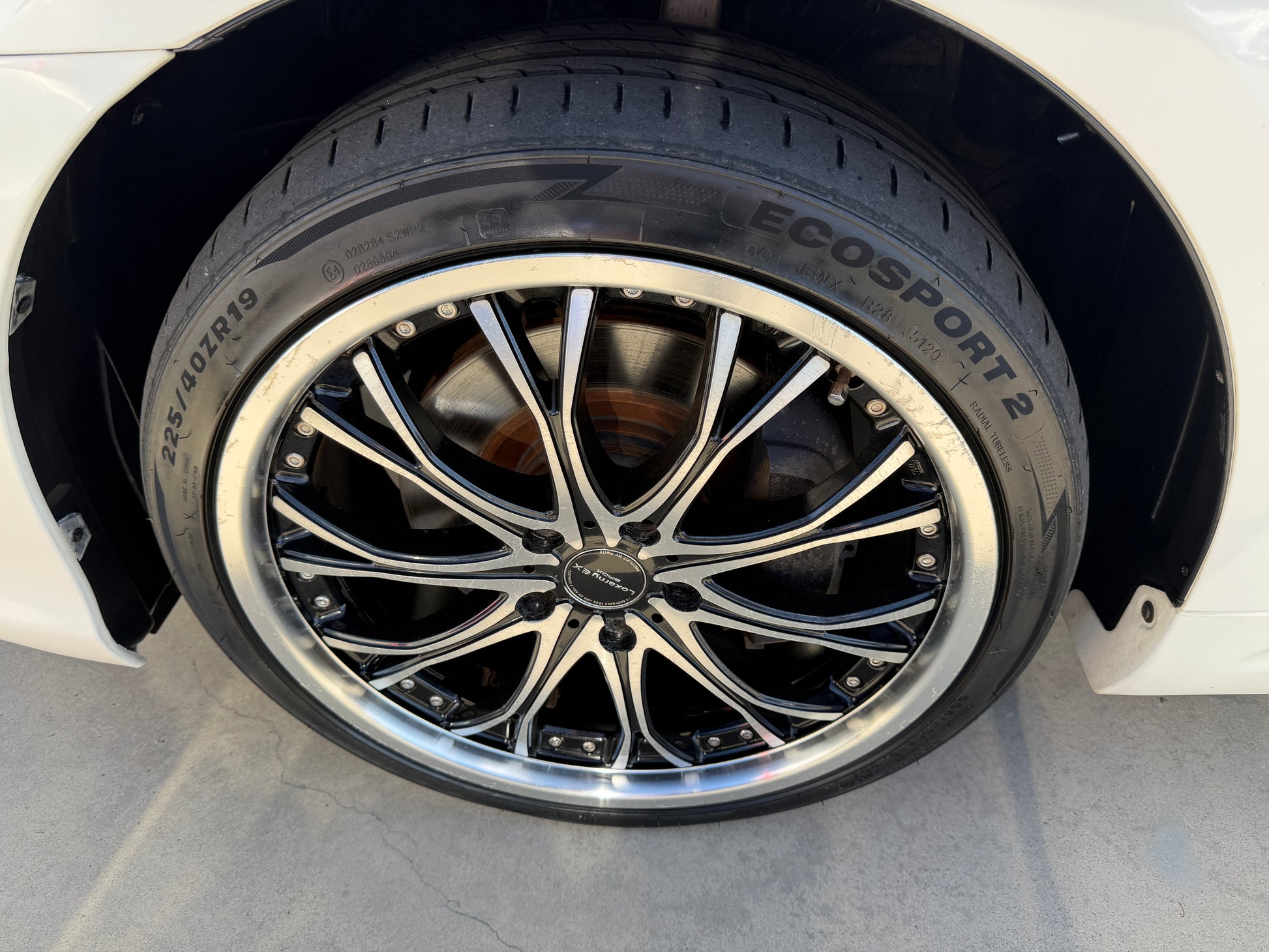 2012 Toyota Crown V6 3.5L Hybrid Close-up view of a stylish alloy wheel on a car, featuring a black and silver design and an ECOSPORT 2 tire.