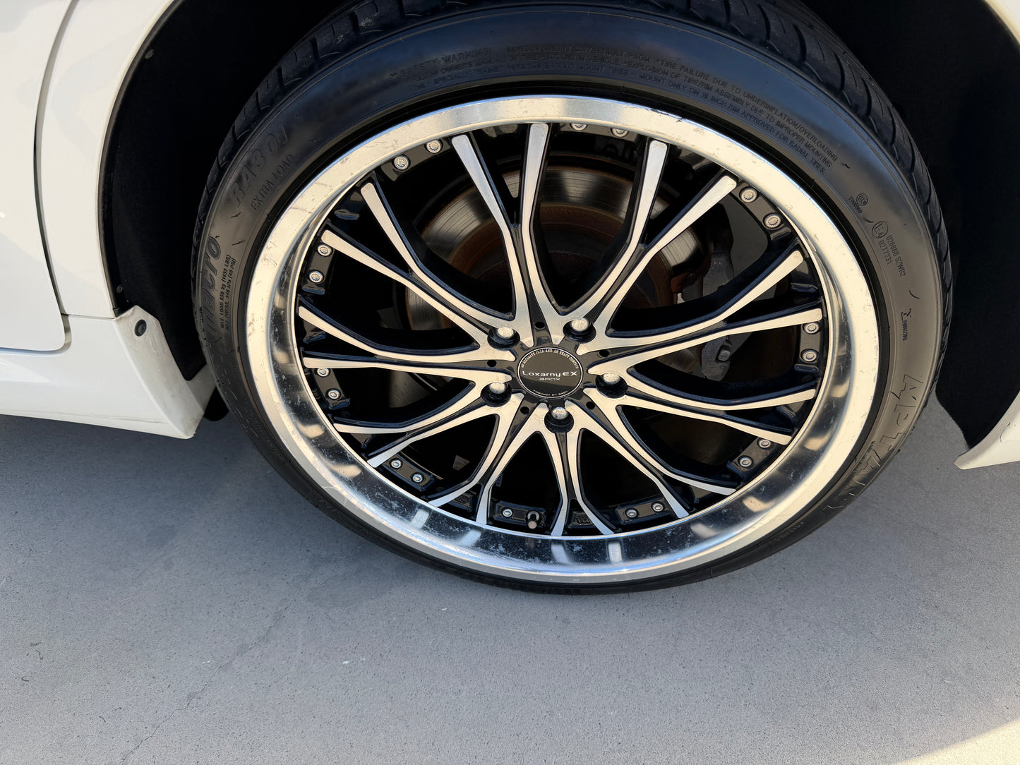 2012 Toyota Crown V6 3.5L Hybrid Close-up of a stylish alloy wheel with black and silver finish on a luxury sedan.