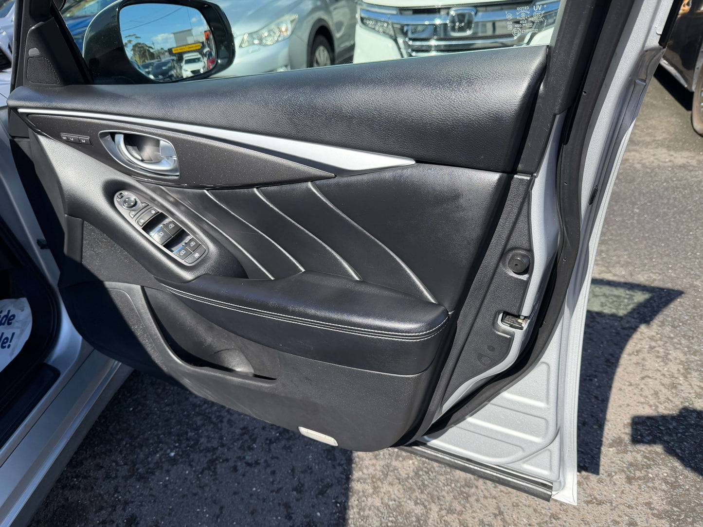 2014 Nissan Skyline V6 3.5L Hybrid door interior showing controls and black leather trim