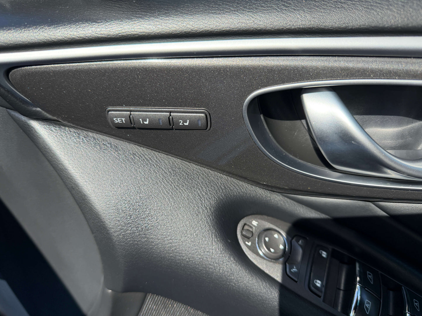 Interior door panel controls of 2014 Nissan Skyline V6 3.5L Hybrid with seat adjustment buttons.