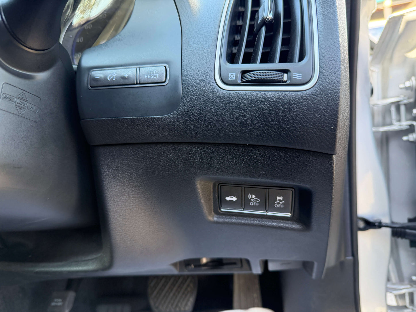Interior dashboard controls of a 2014 Nissan Skyline V6 3.5L Hybrid, featuring ventilation and driving assist buttons.
