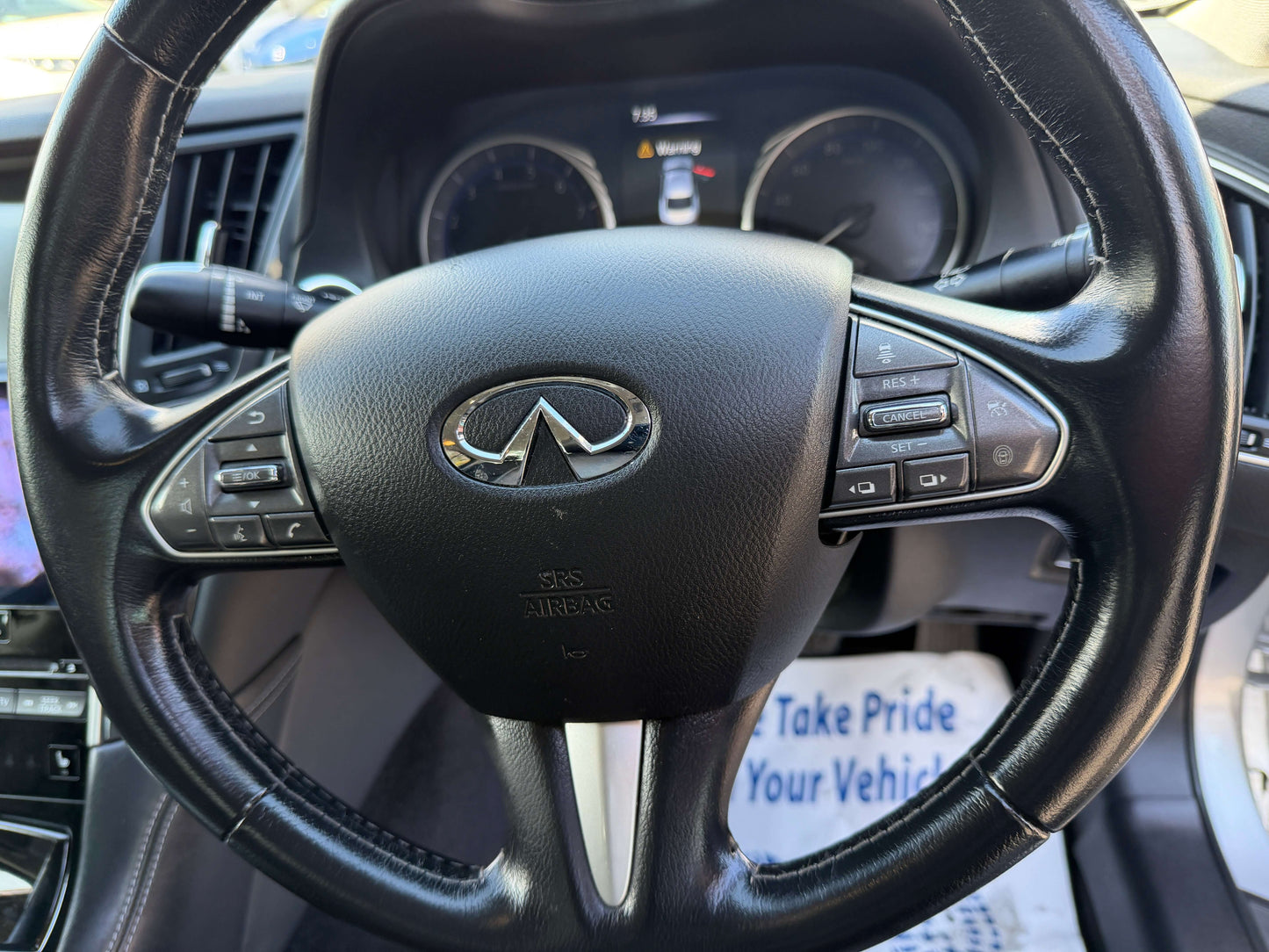 2014 Nissan Skyline V6 3.5L Hybrid steering wheel with Infinity logo and controls for a luxury driving experience.