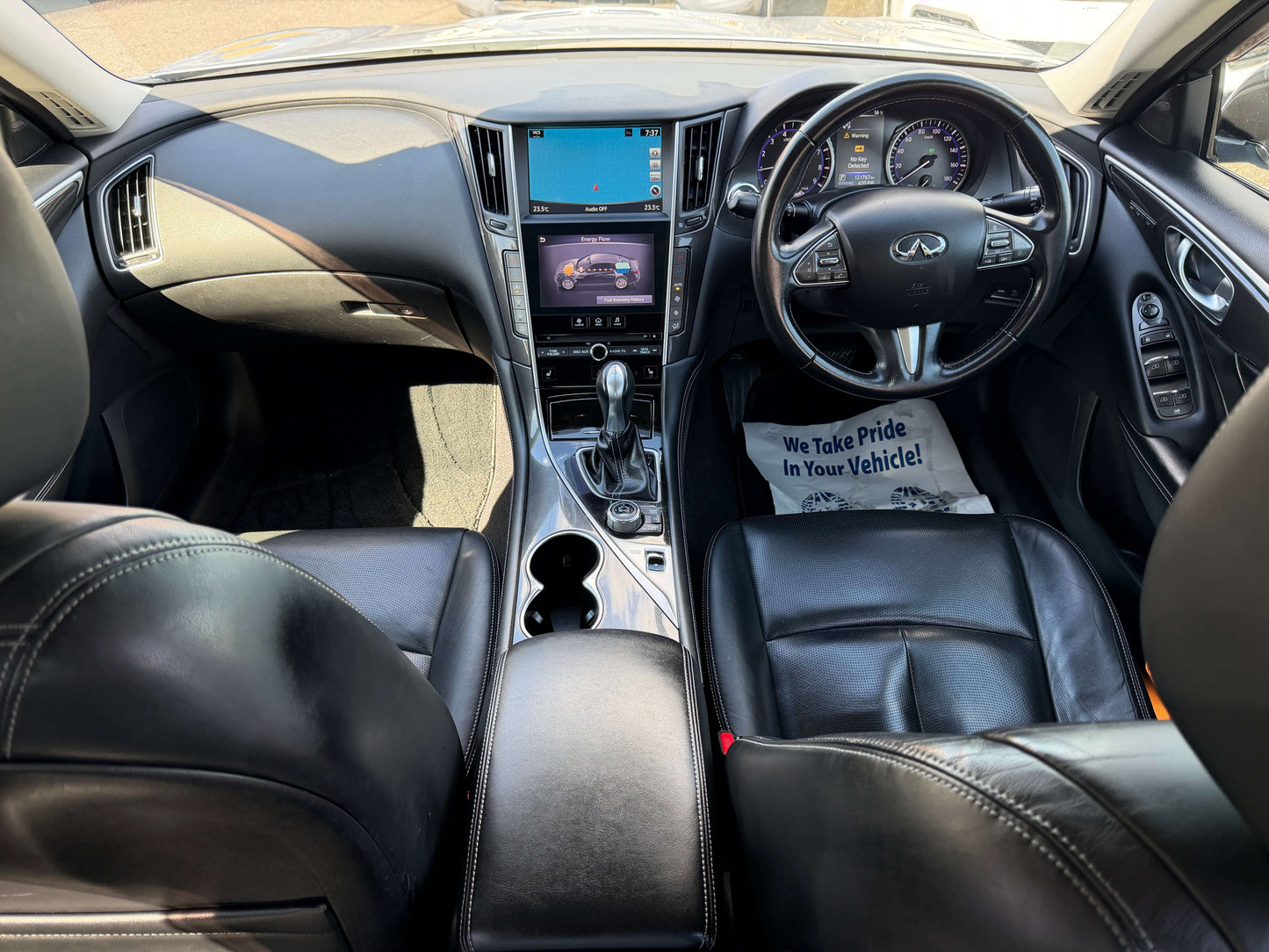 Interior view of a 2014 Nissan Skyline V6 3.5L Hybrid featuring luxury leather seats and advanced dashboard technology.