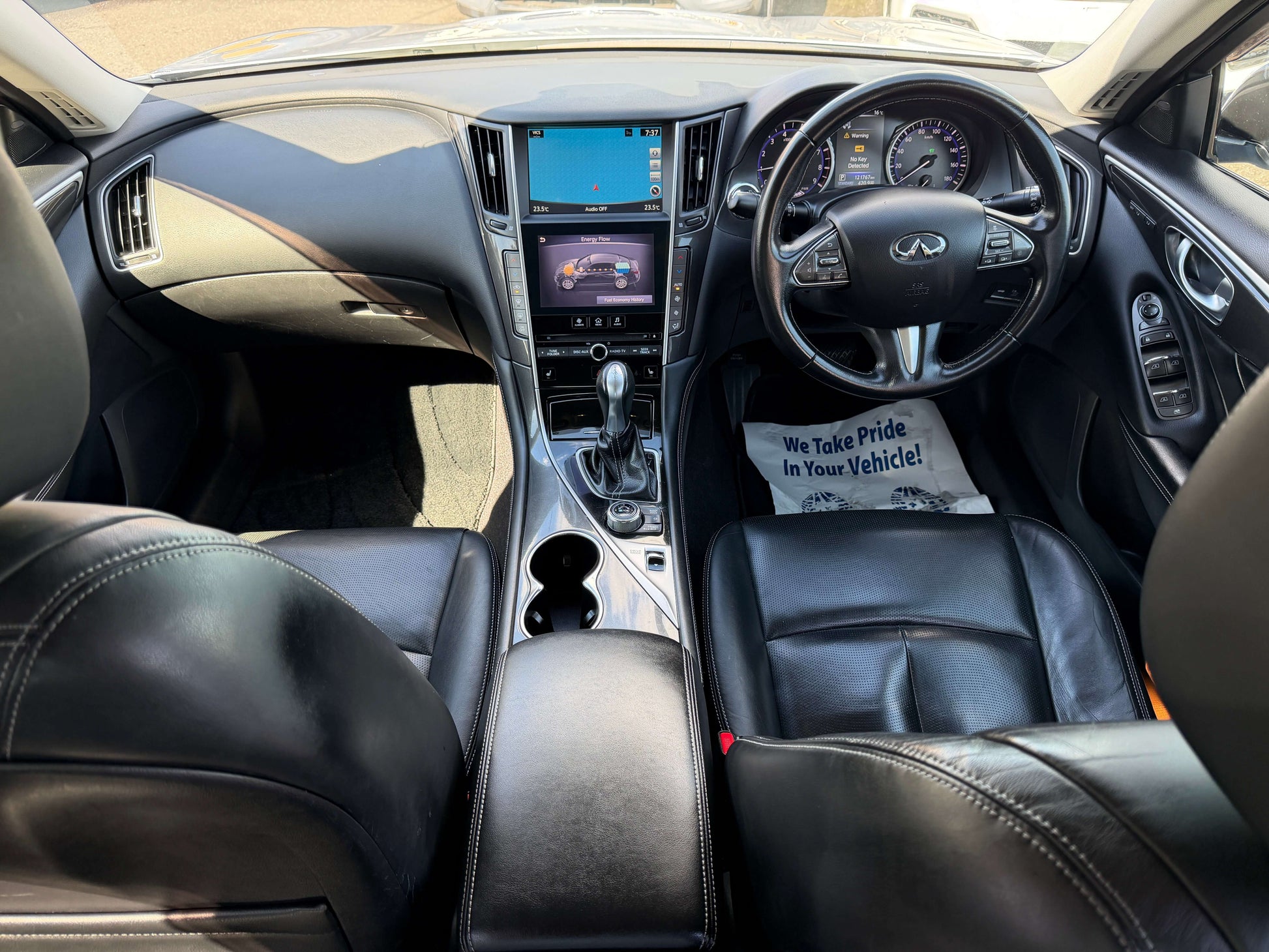 Interior view of a 2014 Nissan Skyline V6 3.5L Hybrid featuring luxury leather seats and advanced dashboard technology.