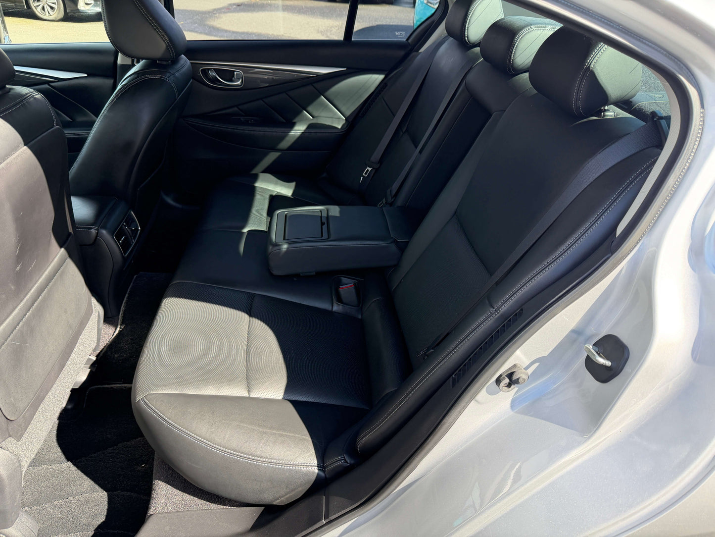 Interior view of the back seat in a 2014 Nissan Skyline V6 3.5L Hybrid sedan, featuring luxurious leather upholstery.