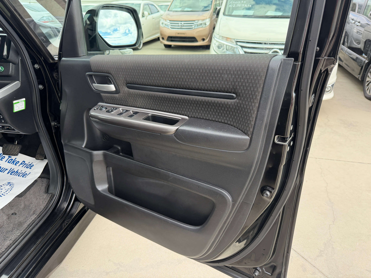 Interior view of the driver side door of a 2018 Honda Honda Stepwgn 2.0 Spada Hybrid, showcasing modern design and controls.