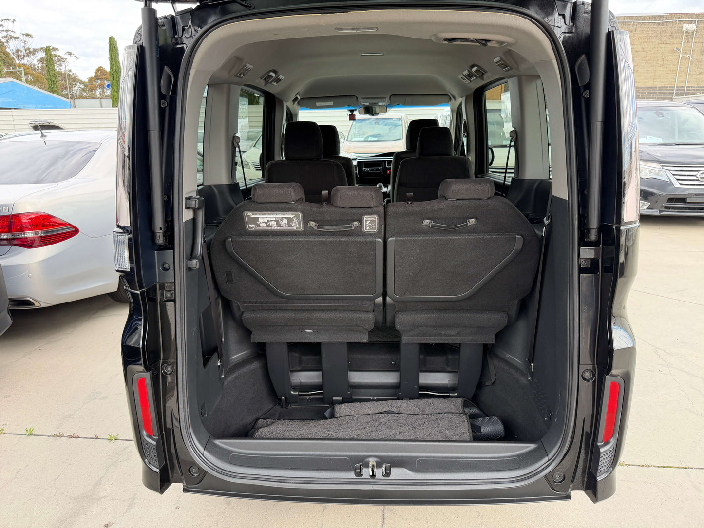 Interior view of the spacious trunk of the 2018 Honda Honda Stepwgn 2.0 Spada Hybrid, featuring ample seating and storage.