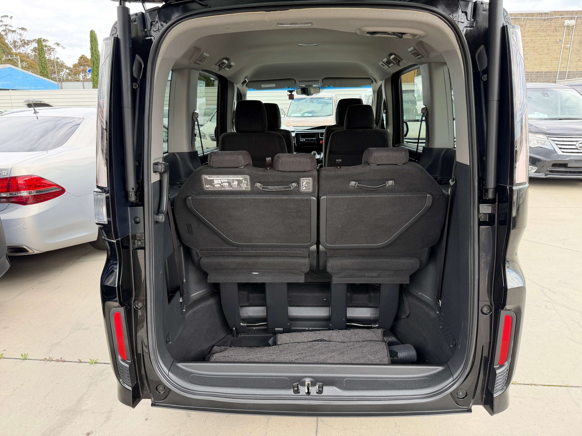 Interior view of the spacious trunk of the 2018 Honda Honda Stepwgn 2.0 Spada Hybrid, featuring ample seating and storage.