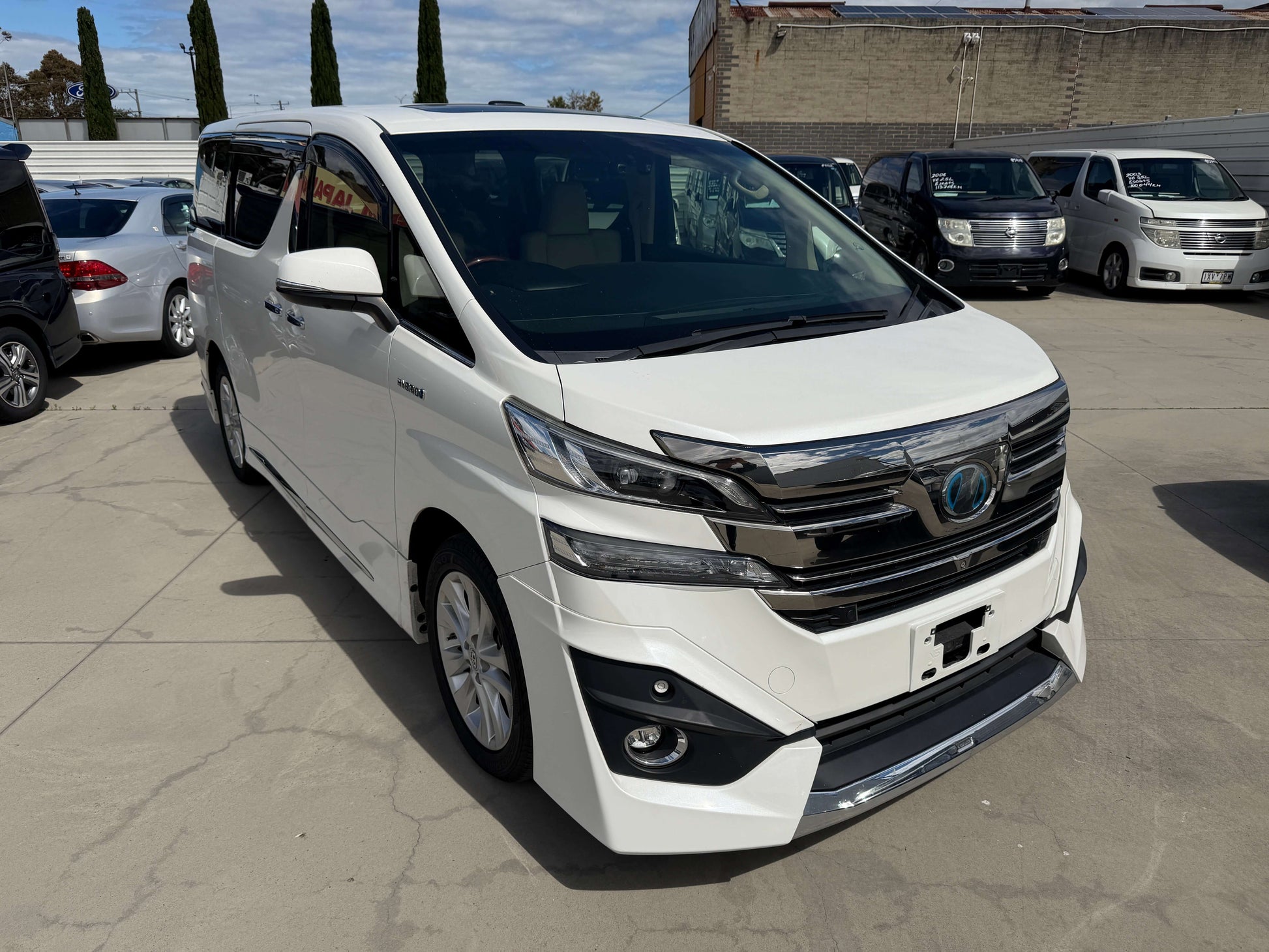 2015 Toyota Vellfire 2.5L e-Four Hybrid V-L Edition in white, showcasing luxury people mover design.