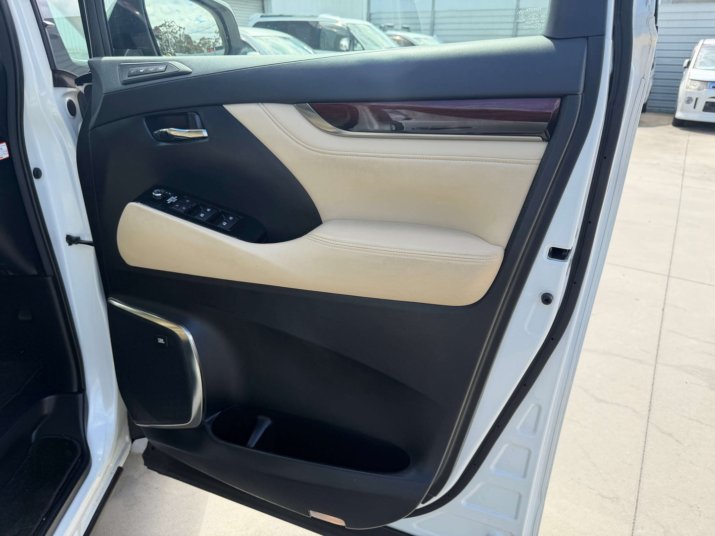 Interior view of the driver's side door of a 2015 Toyota Vellfire 2.5L e-Four Hybrid, featuring elegant design and features.