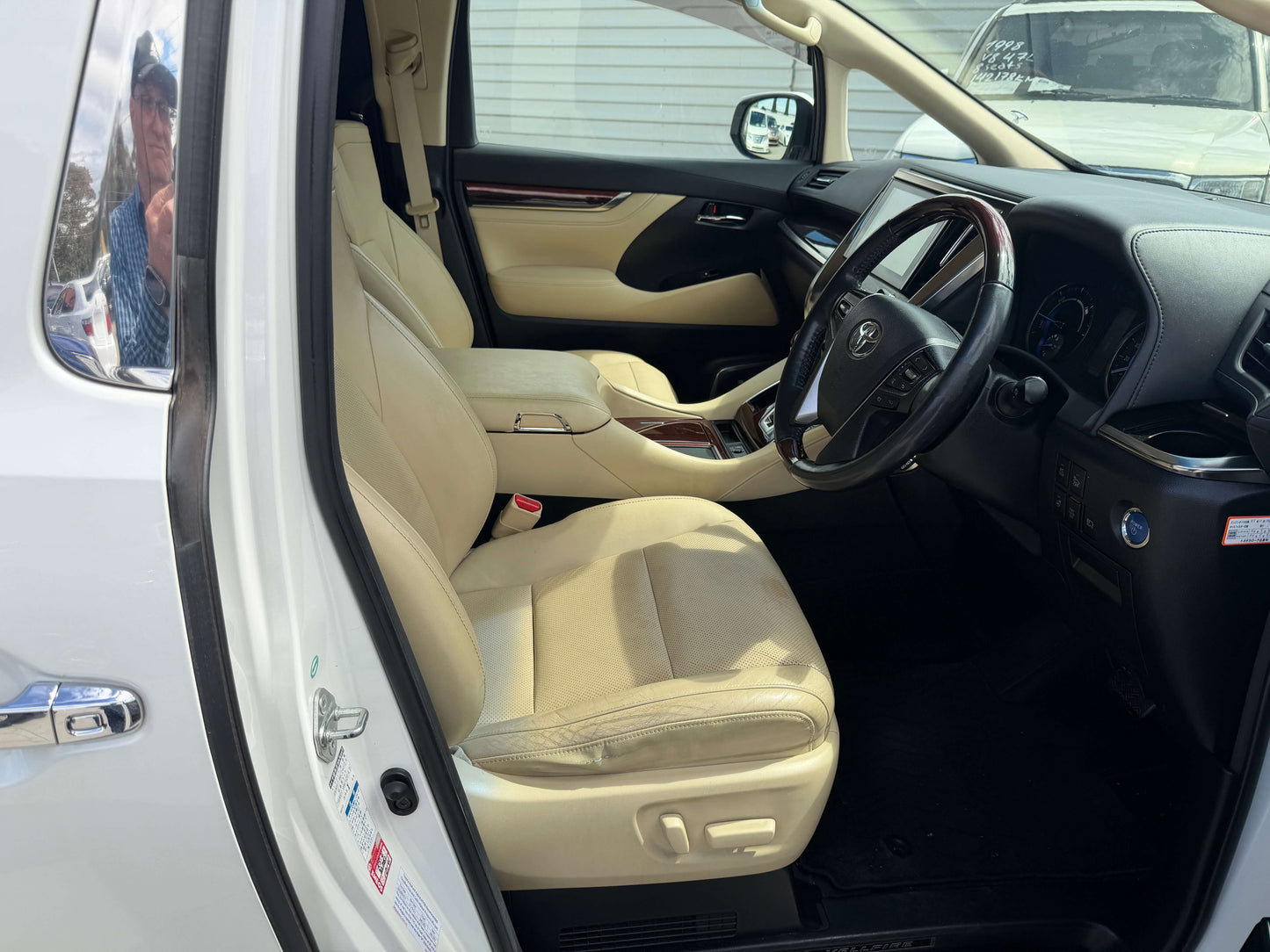 Interior of a 2015 Toyota Vellfire 2.5L e-Four Hybrid, showcasing luxury seating and dashboard features.