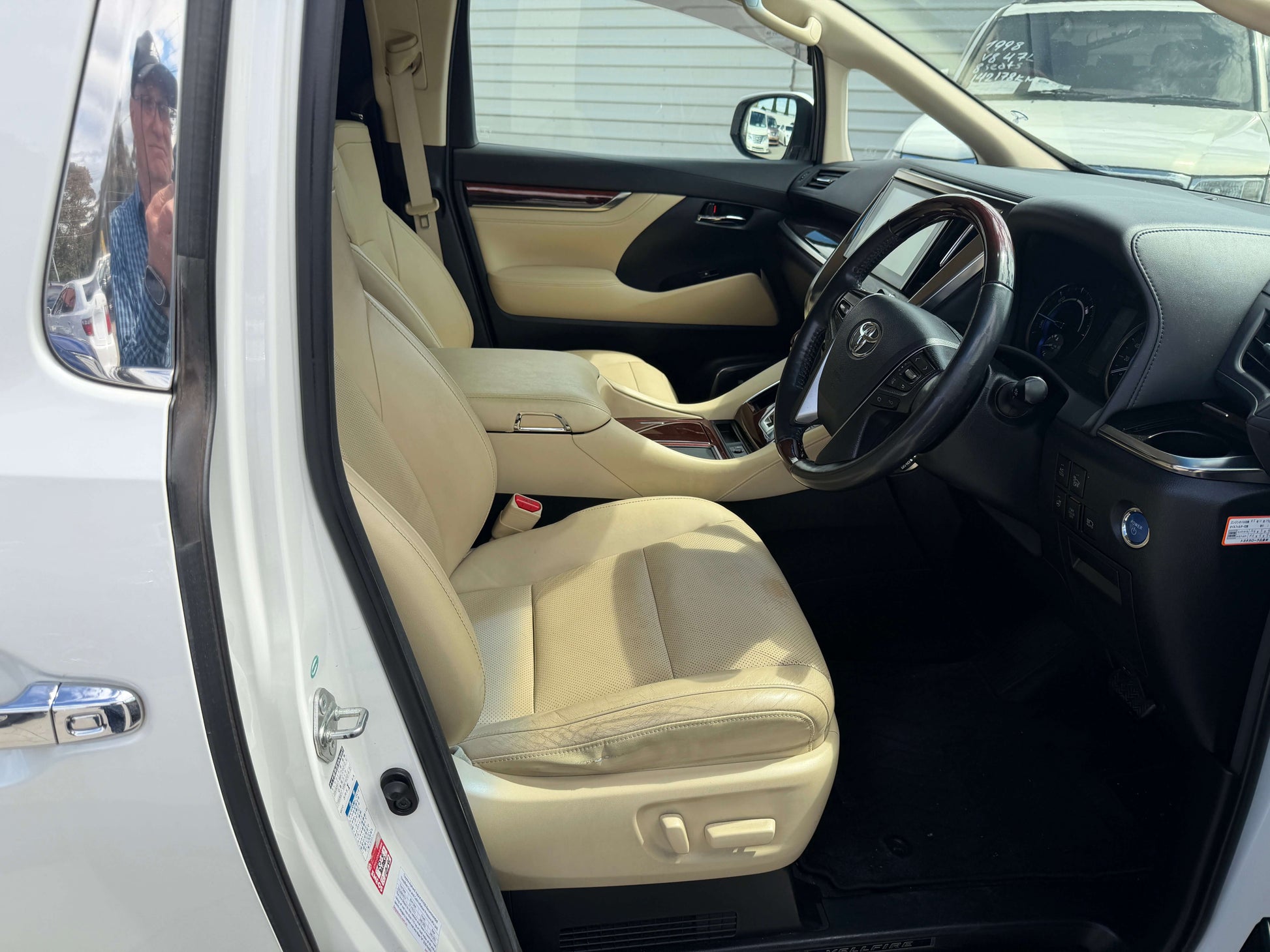 Interior of a 2015 Toyota Vellfire 2.5L e-Four Hybrid, showcasing luxury seating and dashboard features.