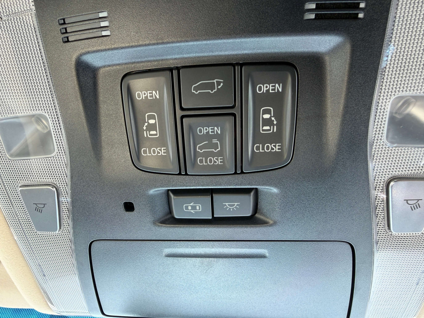 Buttons for opening and closing doors in a 2015 Toyota Vellfire 2.5L e-Four Hybrid interior.