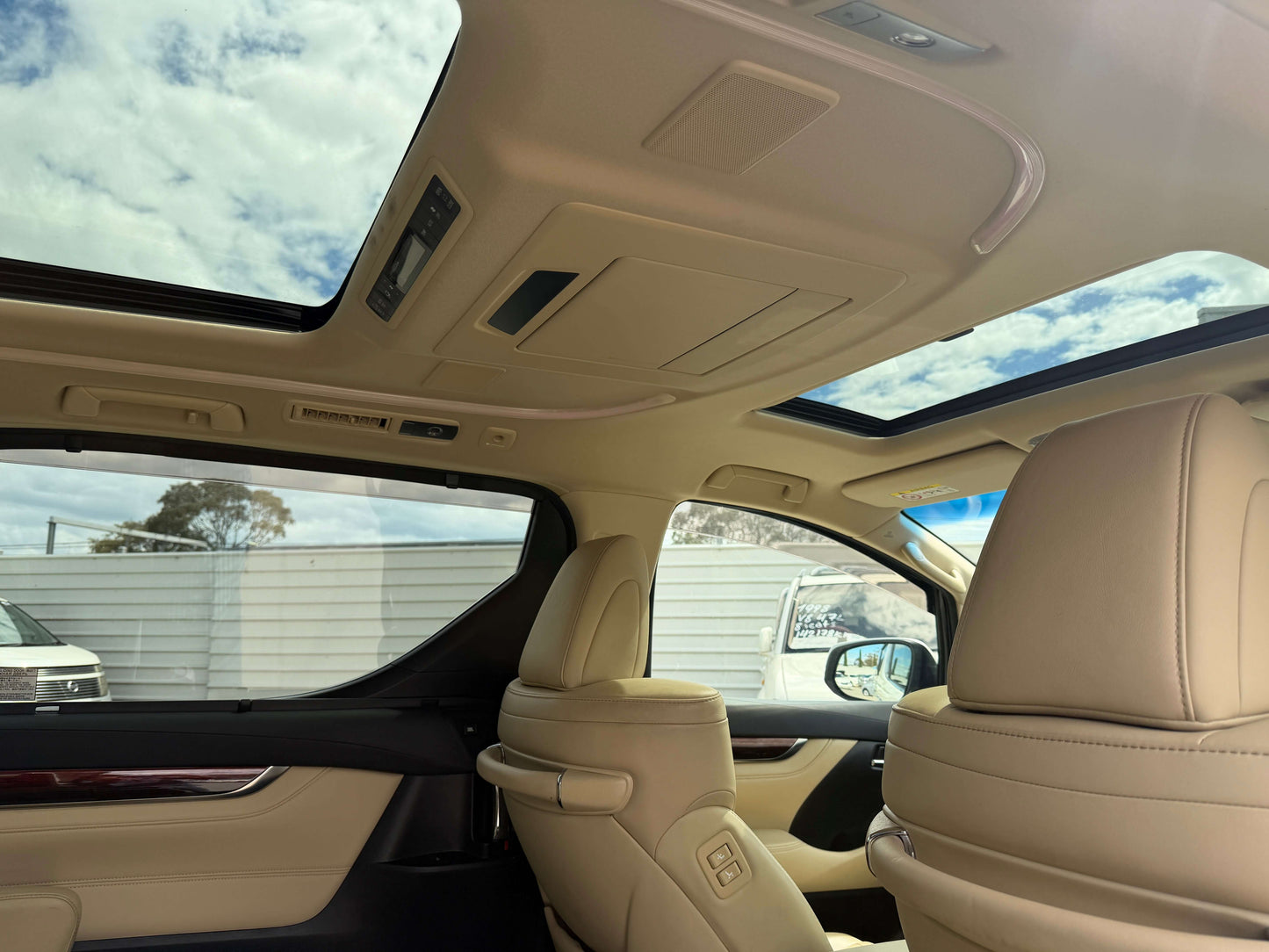 Interior view of the 2015 Toyota Vellfire 2.5L e-Four Hybrid showcasing luxury seating and panoramic sunroof.