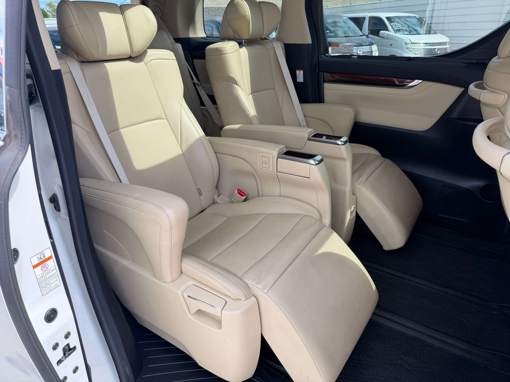 Interior view of the luxurious beige seats in the 2015 Toyota Vellfire 2.5L e-Four Hybrid, designed for comfort.