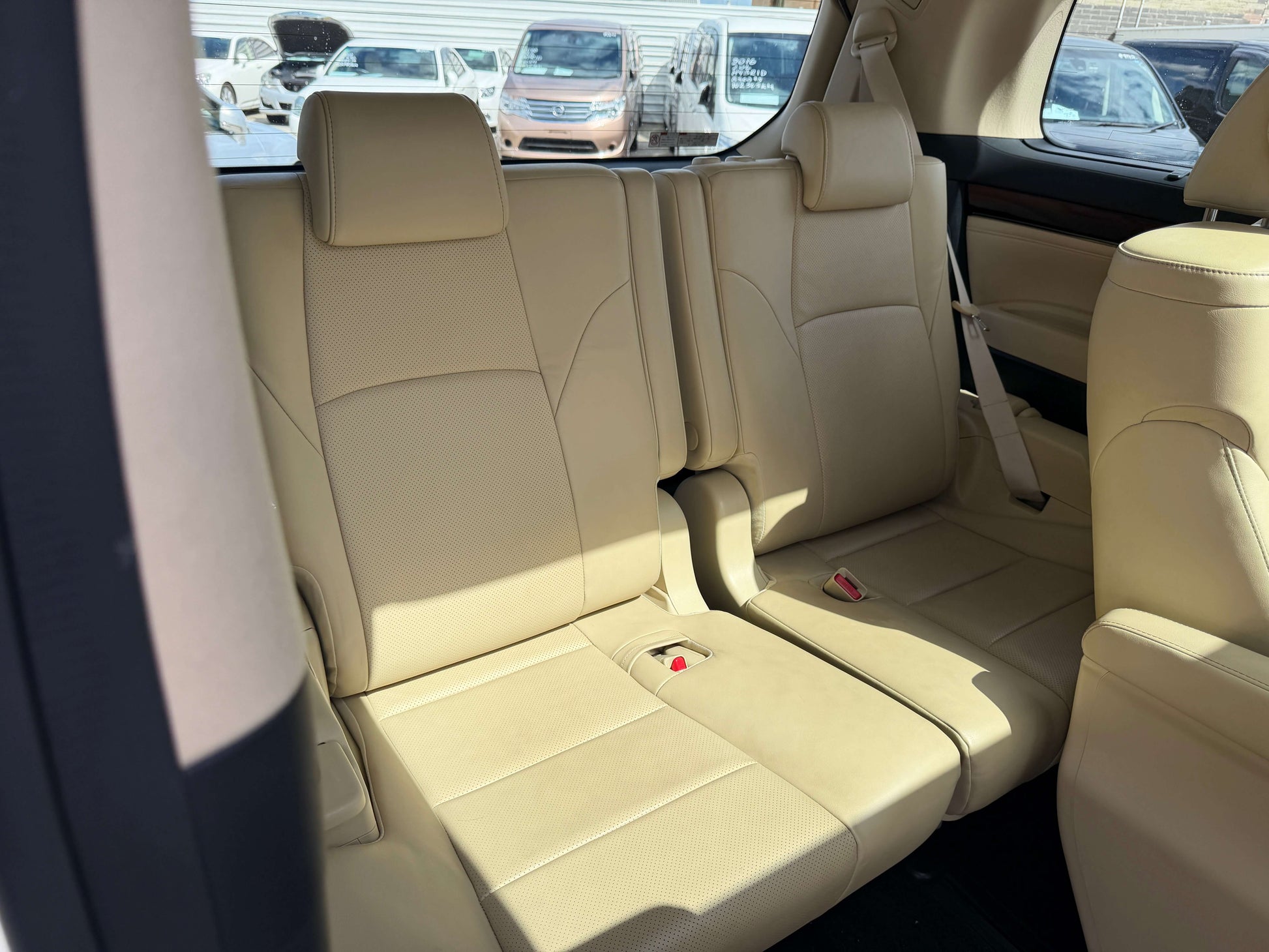 Interior view of the back seats in a 2015 Toyota Vellfire 2.5L e-Four Hybrid, showcasing spacious luxury seating.