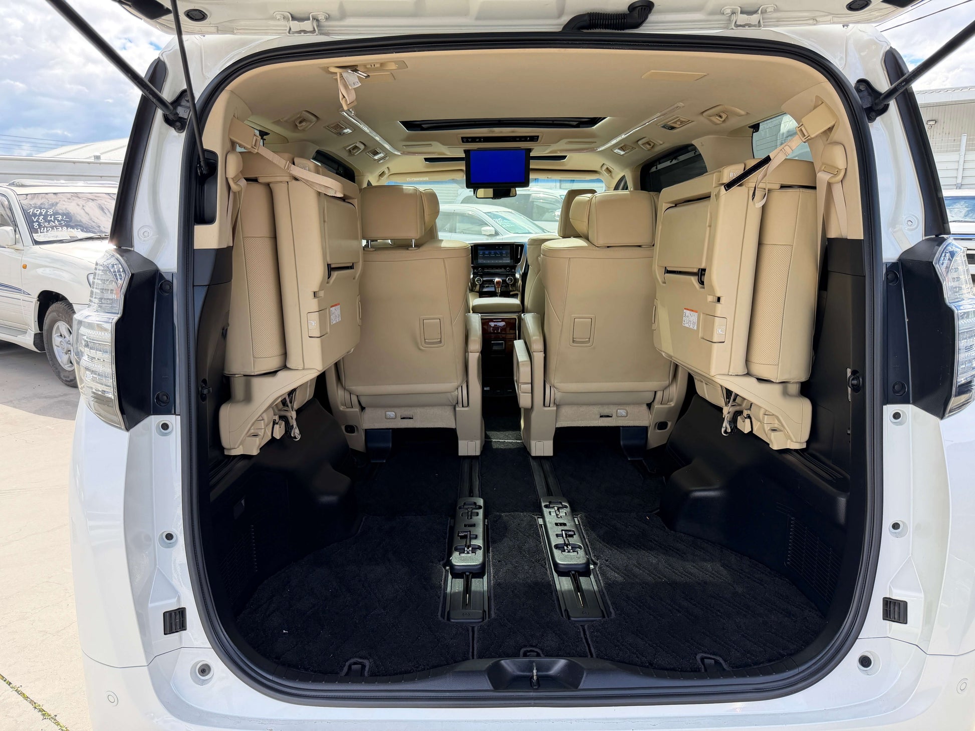 Interior view of 2015 Toyota Vellfire 2.5L e-Four Hybrid, showcasing spacious seating for 7 passengers.